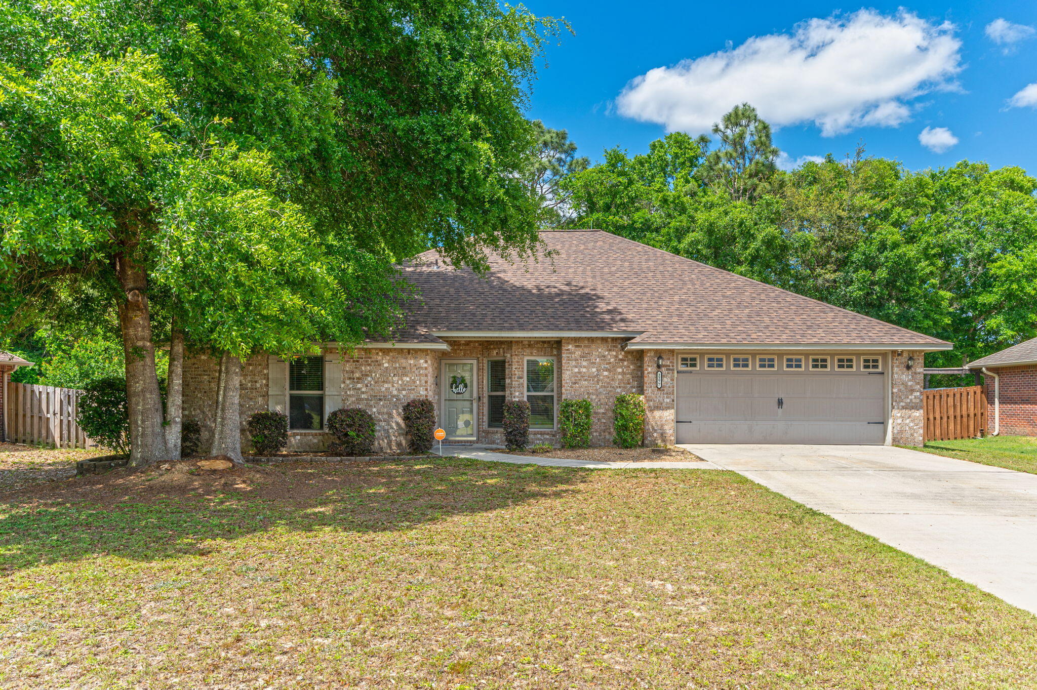 This charming all-brick home in Lee Farm, situated on a level lot in western Crestview, has been beautifully maintained and recently updated. It features four bedrooms and two bathrooms, all enhanced with luxury vinyl plank (LVP) flooring throughout. The home boasts nine-foot ceilings and an open floor plan in the main living areas, creating a spacious and welcoming atmosphere. The kitchen is a cook's dream with new stainless-steel appliances including a dishwasher, microwave, and smooth top stove/oven. It's also been upgraded with new granite countertops, 42-inch raised panel cabinetry, an under-mounted sink, and modern lighting, adding to its elegant appeal. Additionally, the home has received major upgrades in 2023, including a new roof, new AC unit, and  and new water heater, ensuring peace of mind for years to come. The expansive 21 by 12-foot master bedroom is a private retreat located behind the kitchen and features a large walk-in closet and a distinctive ensuite bath with a granite-topped double vanity and walk-in shower.