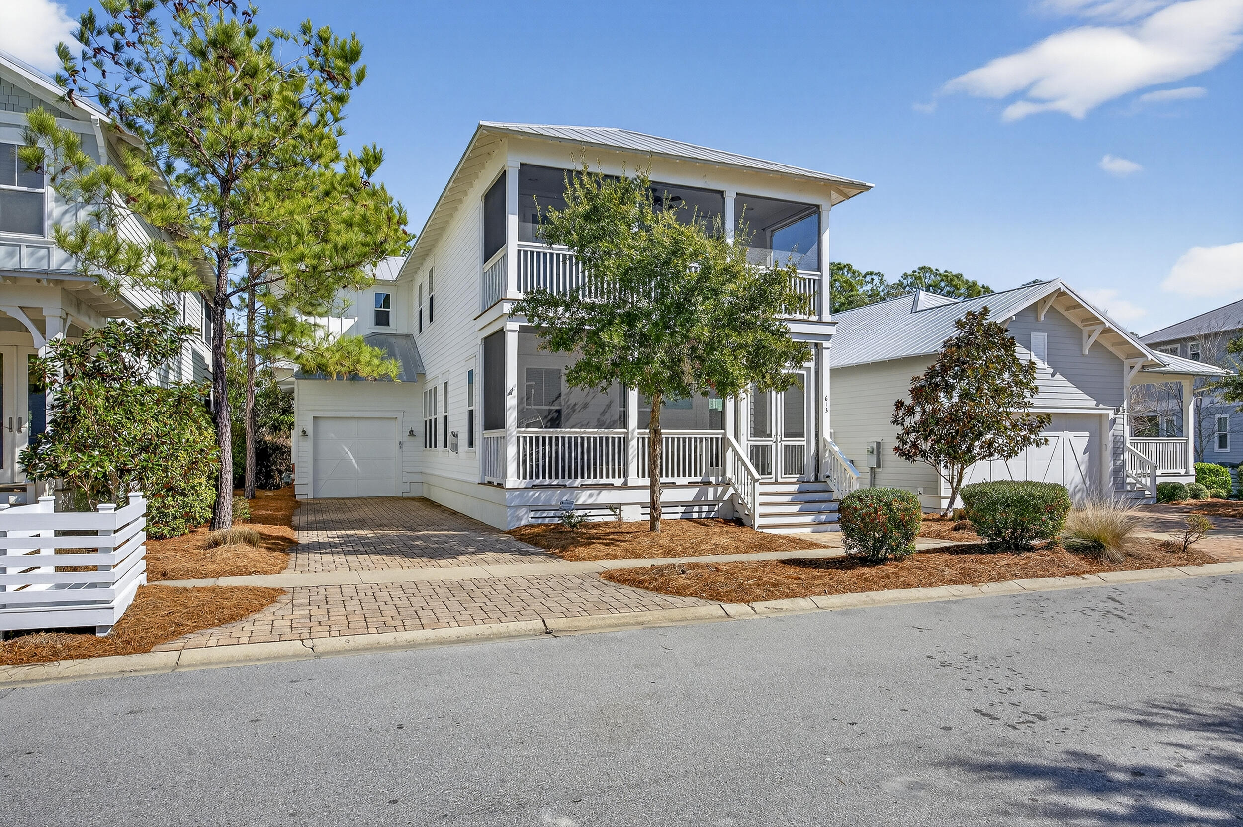 BEST PRICED 4 BEDROOM WITH A YARD. Welcome to 613 Flatwoods Forest Loop in the heart of NatureWalk at Seagrove, a thoughtfully designed home offered partially furnished and including a golf cart. Never rented and beautifully maintained, this residence backs to a serene wooded preserve, offering peaceful nature views and exceptional privacy while being just a short walk to the community pool.
The extended garage provides rare flexibility with room to park both a car and a golf cart. Inside, the living room is warm and inviting with stunning white ceiling beams and a marble surround gas fireplace, perfect for those rare cool beach evenings. Shiplap accents welcome you in the entry and continue up the staircase, adding timeless coastal character throughout. The kitchen is a standout with white shaker cabinetry, marble countertops, and GE Cafe appliances including a gas cooktop, ideal for both everyday living and entertaining. All bathrooms are light and bright with classic marble countertops and subway tile in the guest baths.
The spacious primary suite is a true retreat, featuring a large bathroom with a freestanding soaking tub, generous vanities, and two closets. Step outside to the private screened porch off the primary suite and enjoy tranquil views overlooking nature.
 Four screened porches extend the living space and invite outdoor enjoyment year round. NatureWalk at Seagrove offers exceptional amenities including a resort style pool, heated lap pool, pickleball courts, playground, fire pit, and scenic walking and biking trails connecting directly to the beach and surrounding 30A communities.