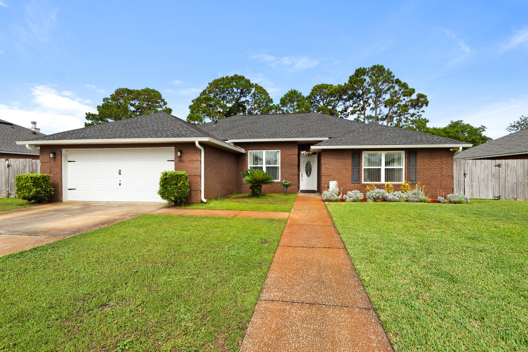 What a coastal beauty! This 4 bedroom 2 bath Gulf Breeze home is amazingly updated and meticulously maintained.  Modern wood tile flooring that runs throughout the entire house.  Crown molding in the main areas of the home and newer light fixtures, ceiling fans and chandeliers add to the coastal feel of the home.  As you walk in the front door to the left is a room that could be an office, dining room, or flex room with wonderful natural light.  Straight ahead is the spacious living room where you will see custom shelving with storage and shiplap surrounding the wood burning fireplace.   Off the great room you will find the updated kitchen with granite counter tops, stainless steel appliances, recessed lighting and dining area.   To the left is the large master bedroom with a lighted tray ceiling.   The master bath has his and her closets with a beautiful free standing bath tub and separate custom tile shower with dual shower heads and a double vanity with a marble countertop.  Such a luxurious spa-like bath!  With the great split floor plan you will find the guest bathroom and three additional bedrooms on the opposite side.  Two of the bedrooms have walk in closets and the fourth bedroom has an extra large closet with bifold doors.  The french doors in the great room, lead to a spacious screened porch plus a concrete patio that looks out to a big fenced in backyard with yard building for your lawn tools.  The outside living space is perfect for coffee or cocktails and outdoor tables  will remain with an acceptable offer.  This neighborhood has unique mailboxes with lamp posts that provide lighting for those evening walks.  Roof, HVAC, and water heater are 2021 and new windows in 2019. Gulf Breeze has A-Rated Schools and white sand beaches just minutes away.  Don't miss this spectacular home! Make an appointment to see it today!