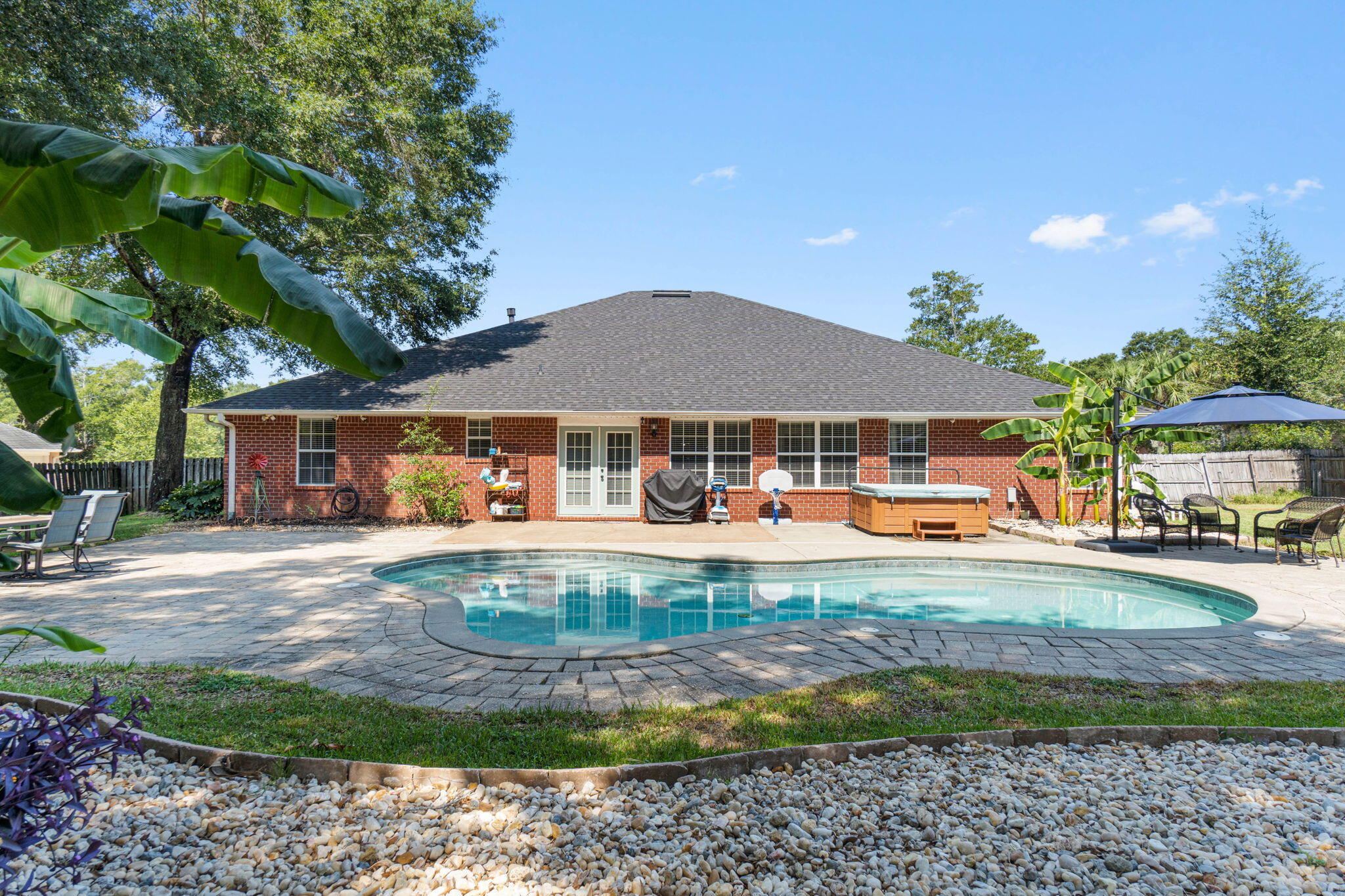 Welcome home to this stunning four bedroom (plus an office, formal dining room and bonus room!), three bathroom home in the desirable Gardenbrook subdivision with a salt water gunite heated pool on an expansive 0.71 acre lot! With a hot tub, 2022 roof, 2022 water heater, a fully fenced in and irrigated massive backyard, and workshop/shed with electricity you're not going to want to miss this one. Pull into the long and oversized driveway and walk up to the front door where you'll find a fantastic covered front porch. Step into the foyer and you'll immediately love the cherry hardwood floors that continue into the main areas of the home. Just to the right of the foyer is the office and to the left is the formal dining room with a doorway leading into the kitchen. The living room is enhanced with open decorative ledges and a gas fireplace. The stunning kitchen features Kenmore Elite stainless-steel appliances, granite countertops, solid wood cabinets, a functional island with electricity, and a pantry. This is no cookie cutter home, you're going to love the antique brick flooring that extends throughout the kitchen, interior laundry room which leads to the 2 car side entry garage, and bonus room! The split floor plan of the home allows for privacy, with two great sized bedrooms and a full bathroom off the living room, and an "in-law suite" off a hallway behind the living room. The massive 13'3"x17'1" in-law suite also has an access door to the bonus room from the full sized bathroom. The bonus room overlooks the gorgeous backyard and is accessible from the in-law suite, the living room and the eat-in kitchen and features two sets of french doors with those gorgeous brick floors. The owner's suite is nestled off the kitchen and is a great oasis complete with a trey ceiling and cherry wood flooring. The owner's en suite features two walk-in closets, a garden tub, double vanity and a tiled walk-in shower. The backyard truly has the WOW factor and is made for entertaining! The gunite saltwater pool deck is finished with pavers and the pavers continue to the fire pit and an extended patio area for seating and is complete with a hot tub as well! The private backyard is large with a children's play set and a workshop and the fully fenced in yard features a double gate. The home has an active termite bond and routine pest control service, the pool pump was replaced in 2023, there is a child safety pool fence located in the outdoor storage building, and the house has a pad and was wired to be able to add a whole home generator! Welcome home!