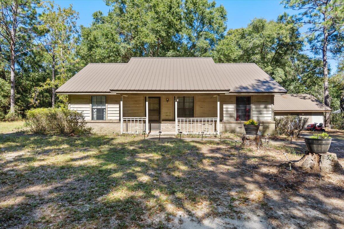 Enjoy your own piece of paradise! Quaint 3-bedroom, 2-bath home with newly added screened porch. This property is on 2.38 acres with plenty of privacy and a peaceful, country feel. Home features a brick gas fireplace in the cozy living room. All bedrooms and bathrooms have new flooring and house has been recently painted. Durable metal roof only 5 years old. Rinnai tank less hot water heater installed in 2019 for endless hot water. Back yard has a spacious 20 x 20 workshop with a 4 yr old metal roof.  Enjoy the serenity of country living while still being close to schools and shopping. The lush wooded back yard offers plenty of room to expand.