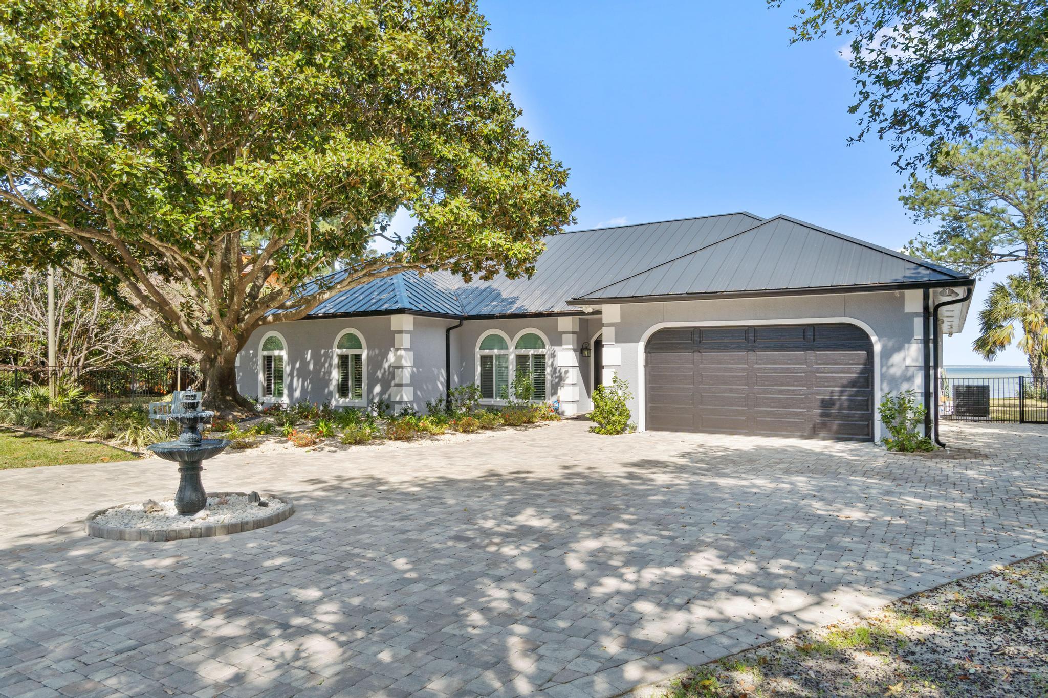 Beautifully renovated waterfront home!  A Great location in the desirable Holiday Shores Estates Subdivision, has no HOA Fees, breathtaking Bay views sitting on over 1/2 acre.  This spacious home is a 3 bed/2.5 bath with two living areas, and a separately enclosed office.  The living areas both walk out to the screened- in heated swimming pool and hot tub area.  The large Master Suite has a fireplace, gorgeous water views and also walks out to the pool area.  The home was completely remodeled in 2020 inside and out.  The interior has an updated gourmet kitchen with new appliances and tons of shelving space.  Beautiful tile throughout, updated bathrooms, extra-large pantry.  The main fireplace was re-done adding sliding barn look doors, new mantel and the list goes on... The exterior has a new metal roof, landscaping and exterior lighting, paver bricks installed in the driveway right up to the main entrance, and a new metal fence around most of the property with a remote entry gate.   Both slider doors leading to the pool area were replaced as well as new impact windows and garage door.  The pool has been resurfaced complete with a new pool filter and water filtration system.  A new enclosure screen and boat lift were installed with a new roof done on the boat slip.  New HVAC, water heater, and security system were also installed in 2020.     A definite must-see home!