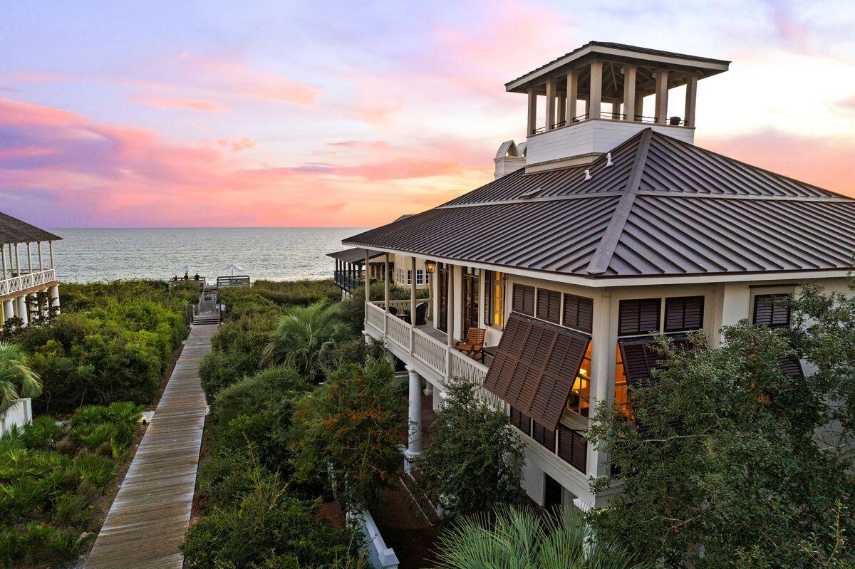 This elegant Rosemary Beach home enjoys panoramic 180-degree views of the gulf enhanced by elevated wrap-around porches, a prominent cupola, and second floor living. The home is ideally positioned one back from the gulf, steps from the sandy beach, on a large lot with 60-foot view corridors. Enter the home through the brick-paved courtyard, passing the private heated pool and lounging area before entering a magnificent foyer with marble flooring. The home's garden level first floor has three en suite bedrooms (two junior suites), bunk room and laundry room. The three garden level bedrooms have porch access for enjoying early morning coffee in the privacy of your own space surrounded by lush vegetation. The second-floor main living area delivers sweeping gulf views through full-height windows with 12-foot ceilings. The second floor creates a seamless flow for entertaining from sitting and dining areas to the upscale chef's kitchen with sub-zero refrigerator, ice machine and beverage refrigerator. Head out to the full-length balcony with dual fireplace and enjoy people-watching in all seasons. The second level master suite is spacious and includes a sunroom with direct gulf views and porch access. The third floor boasts a media room for watching favorite movies or sports with family and friends. Everyone gets a grandstand seat here. A short staircase leads up to the tower and cupola with 360-degree views of the Rosemary rooftops and shimmering Gulf of Mexico. Guests have their own independent home comforts in the carriage house, perched above the garage and adjacent to the courtyard. As well as the sleeping area and bathroom, it includes a dining kitchen and sitting area with a washer and dryer. Built by Ficarra Builders, this masonry home includes unique quality details such as high ceilings, transom windows, planked walls and ceilings, double chimneys, and Chicago brick porch pavers. A standing seam copper roof was added last year. The Rosemary Beach community has the very best entertainment, shopping and dining with a dozen restaurants ranging from casual to gourmet cuisine. Five pools, including an owner's pool and pavilion, along with tennis and fitness centers provide an array of activities within walking distance.