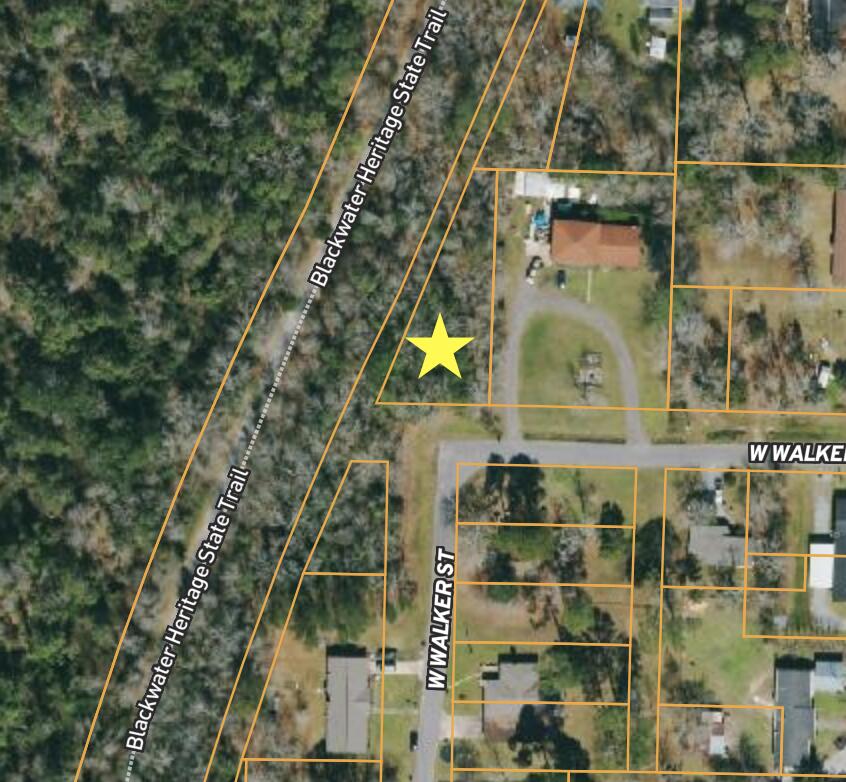 Corner lot next to the Blackwater Heritage State Trail with public water and sewer on site and a power pole out front.  Located on a paved road .  Zoned R-2.  No wetlands.  Less than 45 minutes to Pensacola Beach!  The perfect lot for your dream home or vacation property.