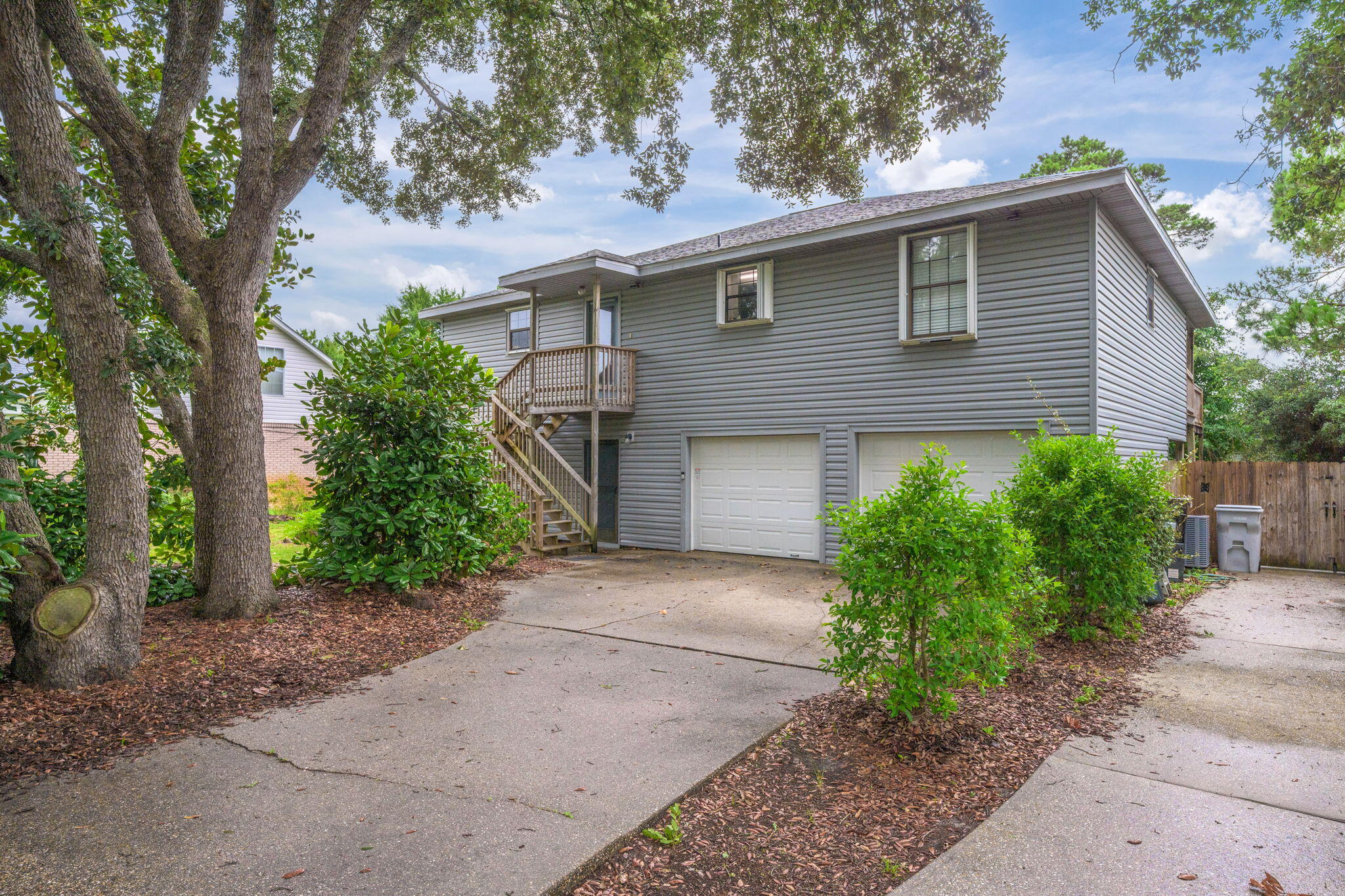 Can you imagine living in a treehouse near the water? This adorable home is just 2 blocks from the Santa Rosa Sound in West Navarre and features primary living space on the second level, offering a peaceful treehouse feel surrounded by mature trees. Perfect for a large family or as a profitable Airbnb -- this property earned $28K in 2024! Tastefully renovated, the recent upgrades include new plumbing, HVAC (including a mini-split downstairs), and beautiful large plank LVP flooring throughout. The spacious master bedroom features a private door to the balcony, a large master bath, and a walk-in closet. The open, split floor plan includes two bedrooms and a shared bathroom opposite the primary suite, plus a sizable laundry closet. One of the two upstairs secondary bedrooms offers its own door to the balcony, where you may think you are sitting in the middle of a forest. The expansive balcony extends across the entire back of the house on both floors, making it ideal for relaxing or entertaining. Additional highlights include low-maintenance vinyl siding, a double attached garage, and two driveways providing plenty of parking. The ground-level storage area was converted into a spacious heated and cooled bonus room, currently used as an extra bedroom, adding approximately 500 sq ft of living space with its own entrance. A crow's nest located off of the upper back porch can be refurbished to offer views of the Santa Rosa Sound and evening sunsets. This home's distinctive style truly sets it apart from others in the neighborhood. Don't miss this rare opportunity to own this unique home near the beach, schedule your showing today!