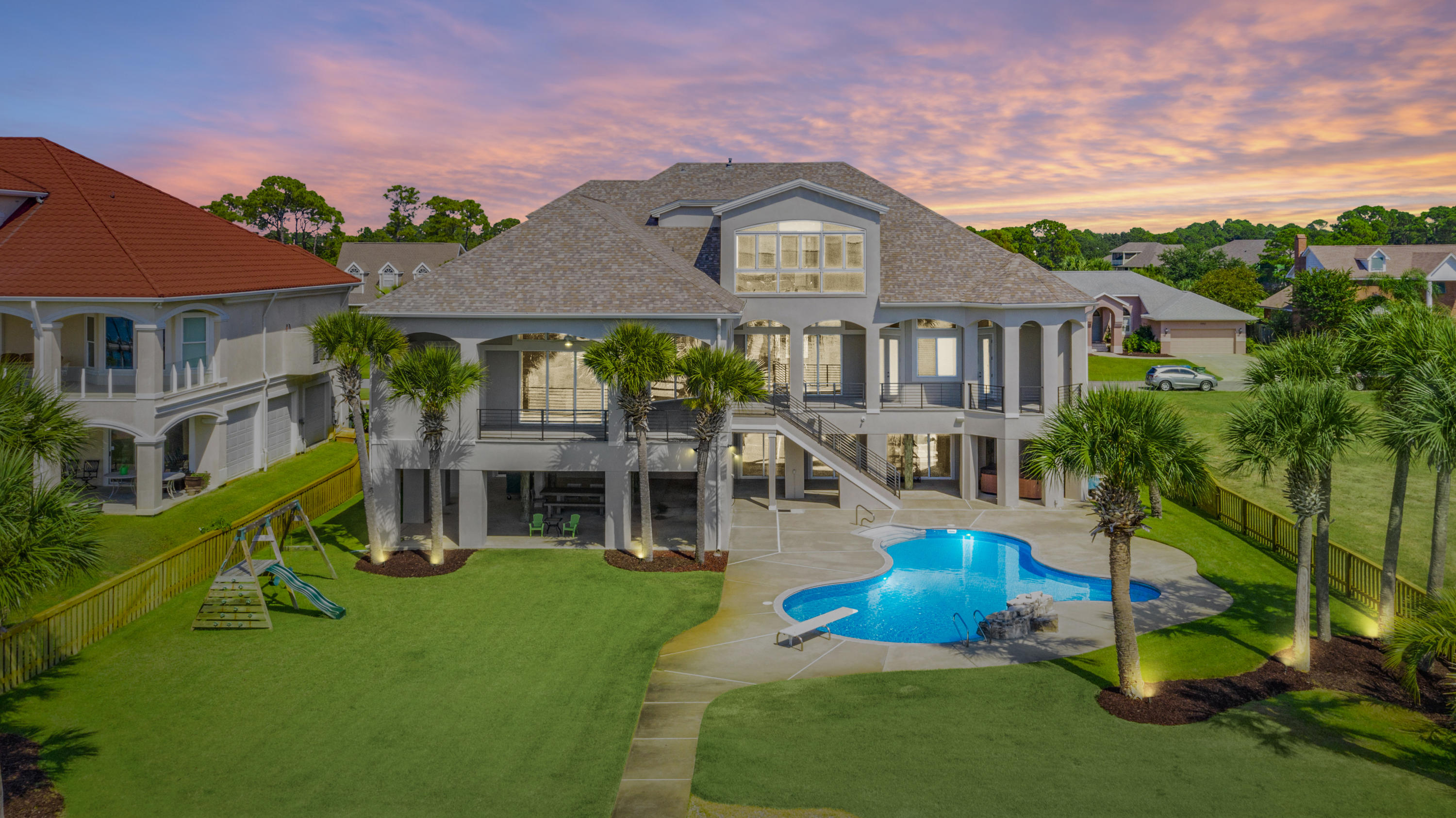 This regal Sound front home resides on the most desirable street in the golf course community of Tiger Point. Upon arrival, you'll note the grand entryway and beautiful landscaping. The open spacious floor plan encourages entertaining with cascading sliding glass doors, opening up to spectacular Sound views onto the covered balcony. You'll also enjoy the oversized dining room, wet bar and pool room while having guests. The kitchen comes fully equipped with two islands, sub-zero fridge, double wall oven, bread warmer and prep sink. The master suite offers sound views, over-sized his & hers walk-in closets and dressing area. Into the master bath with double vanities, soaking tub with a massive shower with 3 shower heads, water closet with a bidet. On the opposite side of the main living flo This regal Sound front home resides on the most desirable street in the golf course community of Tiger Point. Upon arrival, you'll note the grand entryway and beautiful landscaping. The open spacious floor plan encourages entertaining with cascading sliding glass doors, opening up to spectacular Sound views onto the covered balcony. You'll also enjoy the over-sized dining room, wet bar and pool room while having guests. The kitchen comes fully equipped with two islands, sub-zero fridge, double wall oven, bread warmer and prep sink. The master suite offers sound views, over-sized his & hers walk-in closets and dressing area. Into the master bath with double vanities, soaking tub with a massive shower with 3 shower heads, water closet with a bidet. On the opposite side of the main living floor, you'll find 2 additional bedrooms and 3 full baths and laundry room. The third floor holds a media room with a projection screen (Epson Powerlite Pro Camera), kitchen and bedroom with a full bathroom. The office, just off the media room offers amazing floor to ceiling sound views! Enjoy the convenient elevator to the main living floor, for all your needs. Important notables: brand new within 2 years: New roof, 4 new HVAC units, new pool liner, whole house painted inside and out (exterior with 25 year warranty). SMART HOME with a "Control 4 System" which controls the 6 exterior cameras, all home access, sound on all 3 levels, lights, climate control, sprinkler system and fireplace. 2 new exterior staircases with aluminum railing, 2 dehumidifiers on the ground level and 1 in the master bathroom, spray foam insulation in attic and ground floor walls and ceiling, new plumbing and electrical to dock, 2 boat lifts and 1 jet ski lift, landscaping lighting and all new LED recessed lighting. Enjoy panoramic Sound sunsets while lounging in your salt water pool after an epic day boating! Check out our full video tour on the MLS and YouTube.