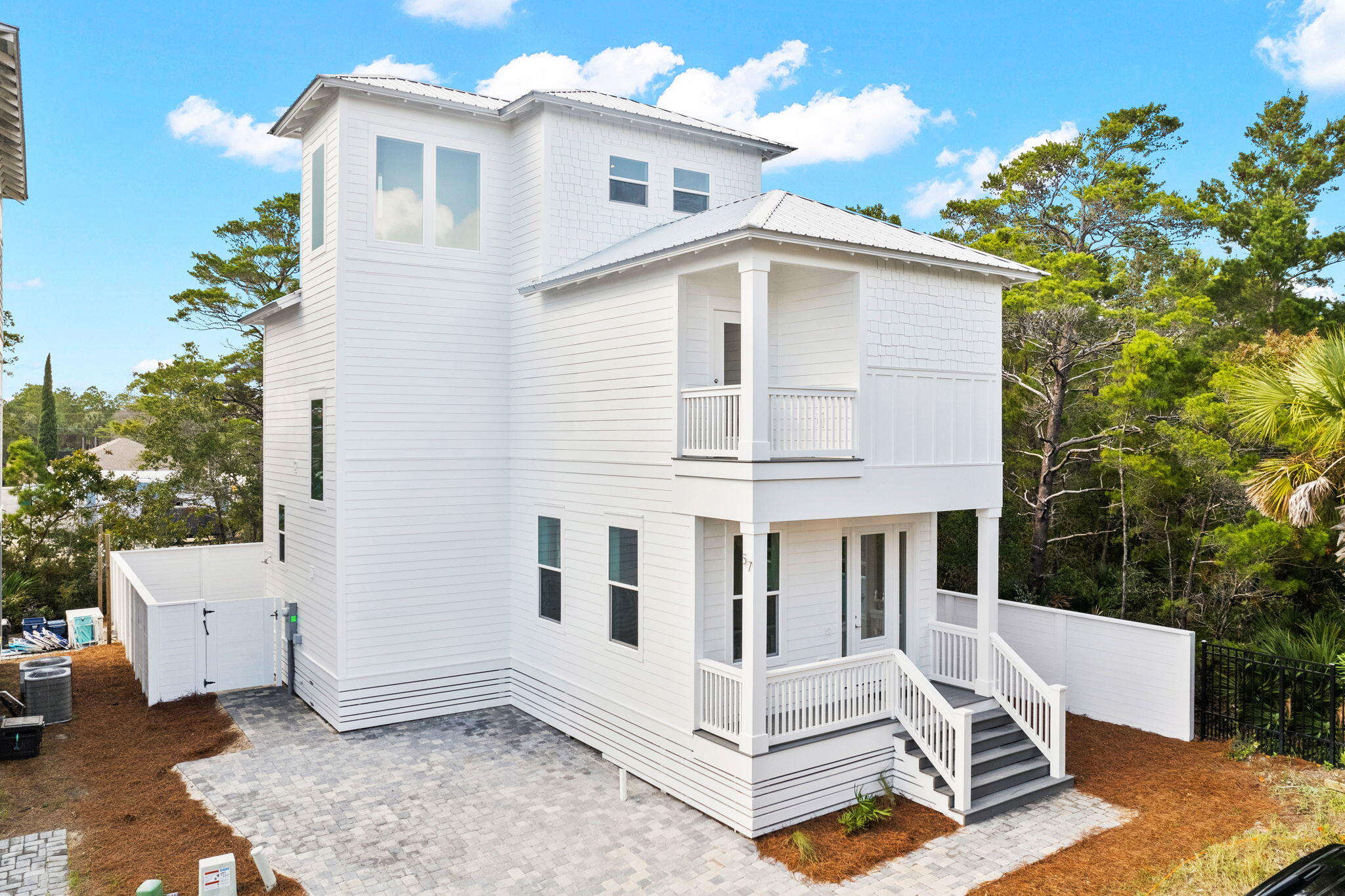 NEW CONSTRUCTION! This home is built to maximize rental income returns. Tucked away on a dead-end street with NO HOA DUES, you are just a short stroll away from the beach access and Gulf Place Town Center offering several restaurants and shopping venues. Three of the bedrooms will offer their own private full bath. The main level of the home will be geared around entertaining, with an open concept flowing from the living area through the kitchen, with access to the private pool area. There is a bonus space which could be used as a bunk room, along with a half bath on the main level. On the second level, you will find the master and two guest rooms, each offering a private full bath. On the 3rd level you will find another large bonus area, which could easily be configured for additional sleeping space. The interior finishes will include LVP flooring, quartz countertops, stainless steel appliances, shaker cabinets, tiled showers and shiplap accent walls. Outside you will enjoy a private heated pool, outdoor cooking area and a paver driveway. Cement hardie board siding, a metal roof and open porches will complete the exterior.