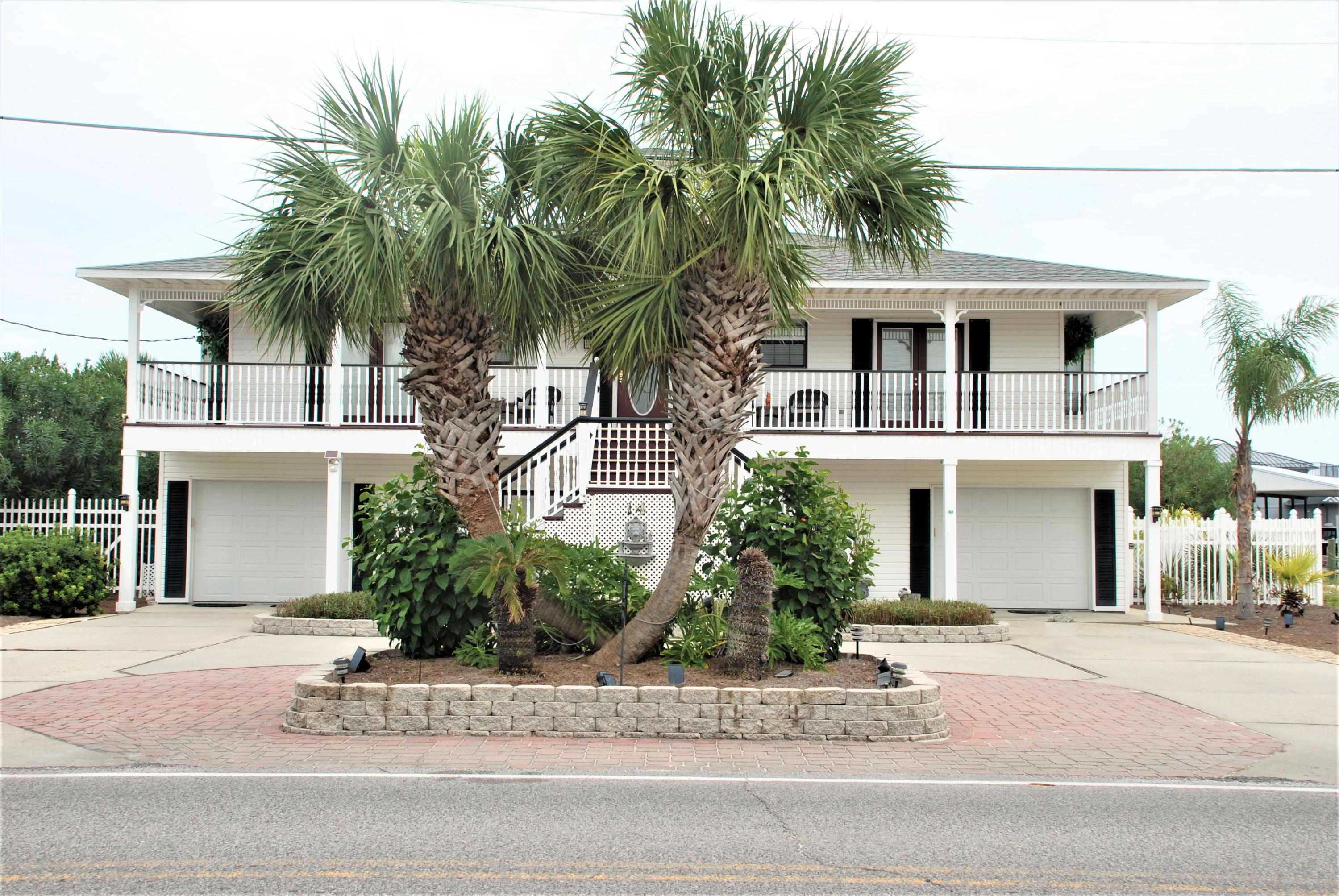 Florida cottage with the absolute best location to be found.  Situated on the Entrance canal with unbelievable views.  Minutes to the Gulf of Mexico from your private slips for fishing or a short walk to the HOA deeded beach access.  4 Bedrooms, 3 Baths, Office, Breakfast area, Dining, Den with wetbar and fireplace, Gameroom, Den on first level, double garage, decks galore, 2 boat slips (one covered), in ground heated pool with waterfall.  Master bath with double vanities, water closet, shower, tub, and sliding doors to back porch.  Spiral staircase to crows nest for amazing views.  Vinyl siding, new roof, lush landscaping, all low maintenance.  The perfect residence or second home is awaiting your inspection and purchase.