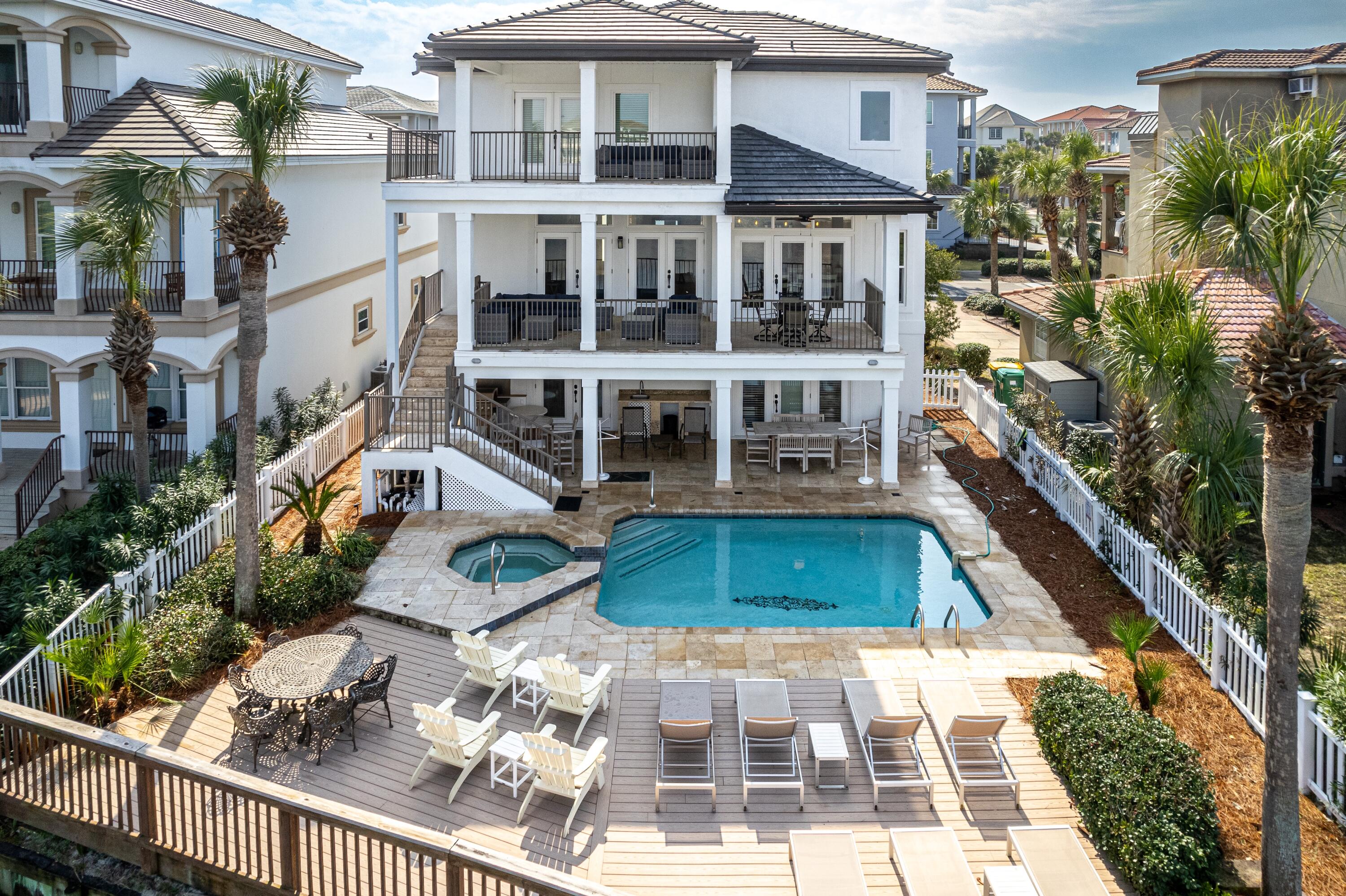 This Dunes of Destin coastal retreat is steps to the deeded beach and nestled between the glistening waters of the Gulf and the tranquil beauty of the lake. The large covered porches and private pool and spa area overlooking the lake invite you to relax and enjoy the salty breeze. Grill dinner and sun by the pool in this vast outdoor space. The home boasts a new roof & the large open floor plan allows for easy entertaining. The kitchen flows seamlessly to the living room and the dining area, which has a large table for gathering. Two oversized master suites open up to spacious porches and include large baths with soaking tubs, separate showers and walk in closets. Other guest rooms on the first level have ensuite baths and include a bunk room for the kids to hang out in their own space. This home has been on a rental program and very well maintained. Most of the windows and doors have been replaced with impact glass, the others have hurricane shutters.  The interior was painted in 2024. The exterior stucco was painted in the past few years. The two car garage is great for storing beach items, along with your cars. This home is conveniently located close to all of Destin's attractions, restaurants, the harbor area, Big Kahunas, and shopping.