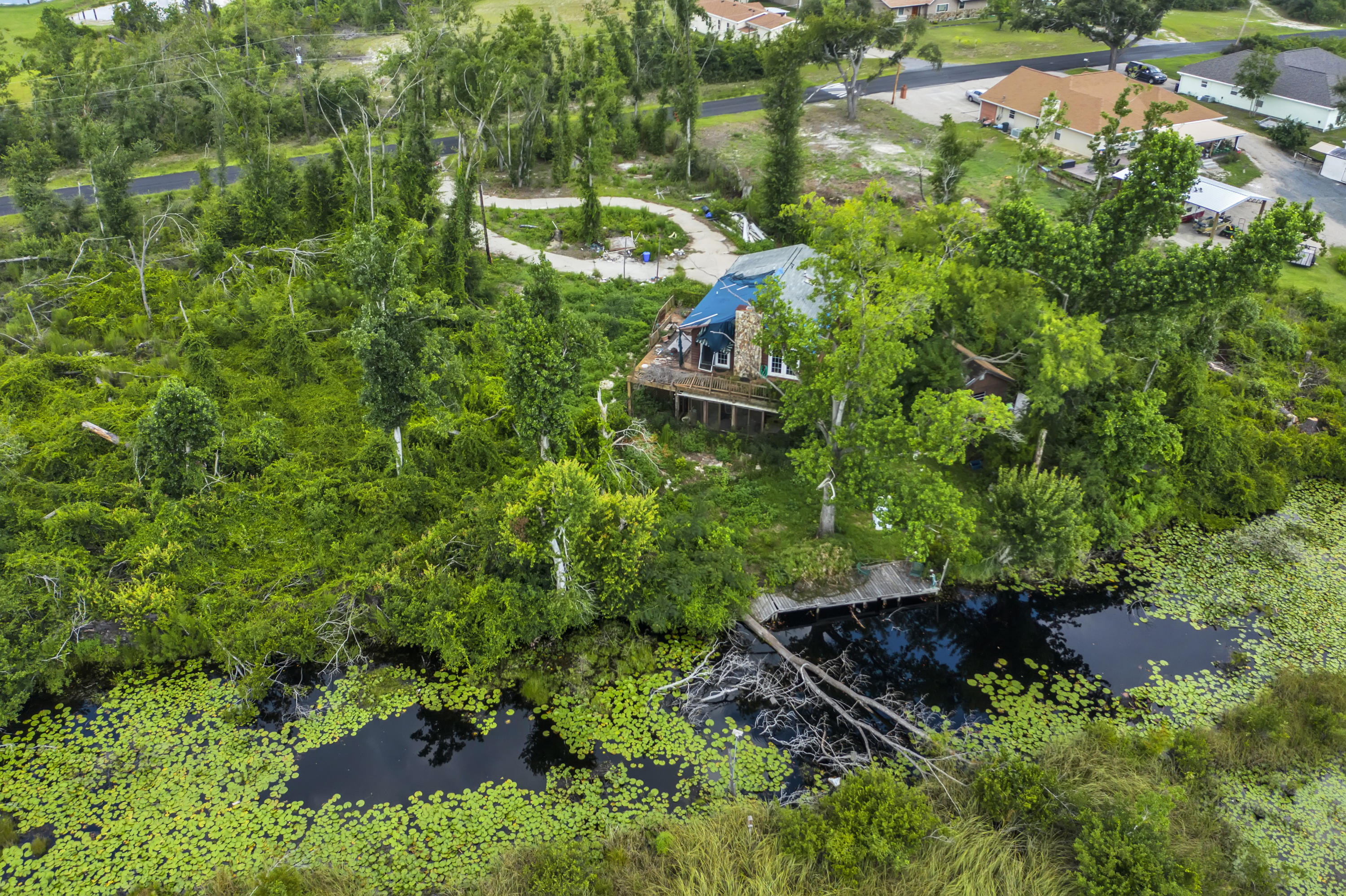 Excellent Location, 19 miles to the beaches, that are acclaimed as the worlds most beautiful ! The current home may be taking down to build your dream estate, or the right buyer could possibly put it back together. This almost 1/2 acre, waterfront lot
has a well, septic, electricity and circular driveway. Everything was working prior to Hurricane Michael, buyer should verify. This location is a secluded, private environment in a great neighborhood, with great views from the dock and the house, offering Vistas, seclusion and privacy. Plenty of room for your boats and recreational vehicles. Pictures taken 7/20/2021