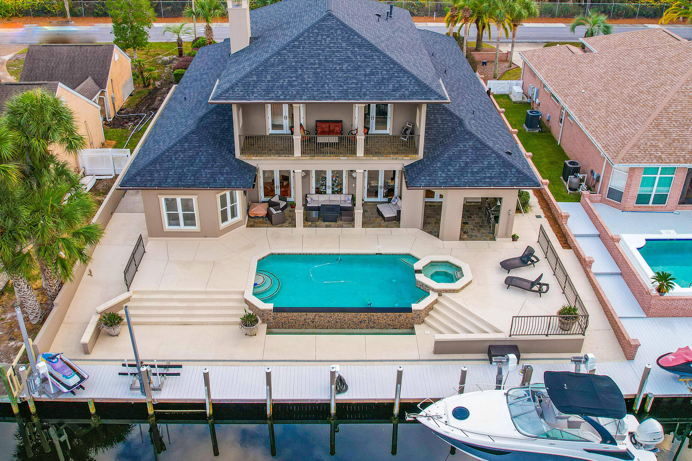 JUST REDUCED!!! Mesmerizing CANAL FRONT home featuring a Heated Infinity Pool w/Hot Tub, Whole Home Generator, Boat Dock/Lift with 2 Jet Ski Lifts, Seawall, Outdoor Kitchen, and Minutes to the Beautiful Gulf-of-Mexico. From the time you enter the grand foyer you can feel the space this open concept home has. The living room is straight ahead featuring river bottom pinewood floors that are outlined with travertine, gorgeous stone gas fireplace, and triple French doors overlooking the pool and canal. To the immediate right is a bonus room, which could be used as a 4th master suite with beautiful custom windows allowing for natural lighting and features a wet bar with an ice maker. The dining room is to the immediate left with custom arches and a stunning chandelier with matching scones. Where do I start with the gourmet kitchen... This is a chefs dream with granite countertops, upgraded appliances to include a six burner Dacor gas stovetop and oven with a separate steamer, warming drawer, built-in refrigerator to match cabinetry, separate convection oven, wine refrigerator, kitchen island with a vegetable sink, all with a travertine backsplash. The amount of cabinetry in this kitchen is amazing with more than enough space for those holiday dishes! The master bedroom overlooks the canal with stunning morning views and the master bath is a dream. Featuring an oversized travertine shower with steamer, double vanity sinks with granite countertops, extensive cabinetry, makeup desk, jacuzzi tub, with a split entry closet with built-ins, cabinetry, and even a built in safe. The laundry is on the 1st floor and includes plenty of working space to include granite countertops, sink, extensive cabinetry, and the washer and dryer remain with the home. The second floor features a large open bonus room, currently set up as a gym, but could be used as a 2nd living room, office, playroom, or anything your heart desires. The custom windows allow for beautiful natural light and there is even a wet bar with a sink and refrigerator for entertaining. There is a large walk-in storage off the bonus room that is 14.6x5.11, that also includes pull down attic storage. The other two bedrooms face the canal/pool, and both feature French doors leading out to the 28.8x7.7 covered balcony with a beautiful view of the outside entertaining area. There is also a full bath on the second floor with granite countertops and double vanity sinks. This home has so much to offer and attention to detail and elegance defines this home. The custom brick paver circular driveway compliments the stunning grand entrance and lush landscaping surrounds the home. The back of the home is where you will spend most of your time. The backyard is an entertainers dream featuring a 43.10x10 covered porch with an outdoor kitchen, gas grill, sink, and refrigerator, outdoor shower, outdoor bathroom, beautiful infinity pool with edge overflow, hot tub, 10,000lb boatlift with water/electricity, and two jet ski lifts. There is too much to mention on this home with the limited characters we have, so please ask your realtor to print out the key feature sheet from the MLS. Additional Features and upgrades include: New roof, gutters, soffits-2020, 3 AC units with one new in 2022, Pool heater replaced 2020, Polaris and pool pump replaced 2020, new interior and exterior paint, Pool decking/seawall was structurally reinforced in 2020, garage floor recently painted, alarm system, lawn irrigation with a separate meter, upgraded lighting, Navien tankless water heater 2019, 12-ft ceilings on the first floor with 13 inch crown molding, surround sound on the 1st floor, and other than the 2 bedrooms upstairs which are carpet, the home is all river bottom pinewood or travertine flooring. If you are not familiar with Bay Point, it is our premier gated community with 24-hour security. This private waterfront community features a newly built full-service Marina, located within minutes to the pass accommodating boats as large as 130 feet, Jack Nicklaus golf course, tennis, spa, restaurants, and even their own post office. If this sounds like the home you have been looking for, contact your realtor for a private showing before your dream of owning a piece of luxury becomes someone else's reality. Age, Sq.Ft., Room dimensions, schools, taxes, are all estimates. It is the buyer's responsibility to verify by a personal or professional inspection if important.