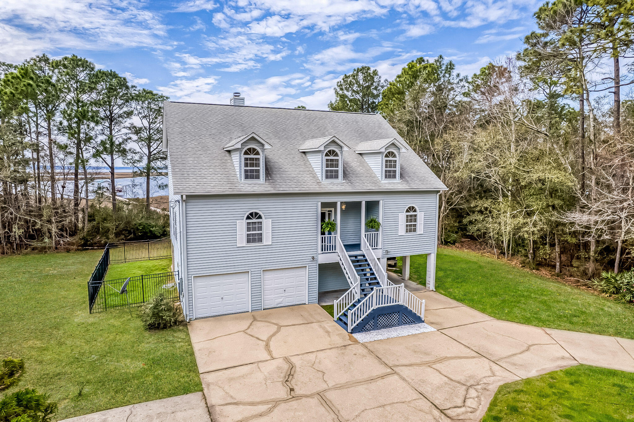 BACK ON MARKET AT NO FAULT TO THE SELLER! Move into instant equity with endless potential in this exceptional three-story waterfront retreat! This property is tucked away at the end of a quiet dead-end street for maximum privacy! Offering sweeping bay views from nearly every room, this 4-bedroom, 3.5-bath home is perfectly built for both tranquility and convenience. Highlights include a private pier, boat dock built with ThruFlow, a 32,000-lb boat lift, and a fully automatic electric dual jet ski lift (easy to operate with a remote) - all while being just 5 miles from I-10 and 9 miles from Pensacola International Airport. The main level features an open and inviting living area with built-in shelving, a cozy fireplace, and new LVP flooring, all seamlessly connected to a screened-in covered patio equipped with no-see-um screens, ideal for enjoying waterfront breezes year-round. The spacious kitchen provides abundant cabinetry and prep space, complemented by a formal dining room and a sun-filled breakfast nook. Just off the kitchen, a deck offers the perfect setting for outdoor dining with scenic bay views. The primary suite on the main level serves as a private retreat, featuring its own screened patio, a spa-like bathroom with a soaking tub, walk-in shower, dual vanities, a generous walk-in closet, and direct access to the laundry room. Upstairs, three additional bedrooms offer flexible living options, including a secondary suite with its own private bath and double closets, plus two additional bedrooms that share a full bathroom. The oversized two-car garage offers a workshop area, refinished floors, two storage closets, and washer/dryer hookups. Additional highlights include a fenced pet area with doggy-door access from the second floor and a covered two-car carport for extra parking. With easy access to Gulf Breeze and downtown Pensacola, this bayfront sanctuary is the perfect place to relax, entertain, and fully embrace life on the water!