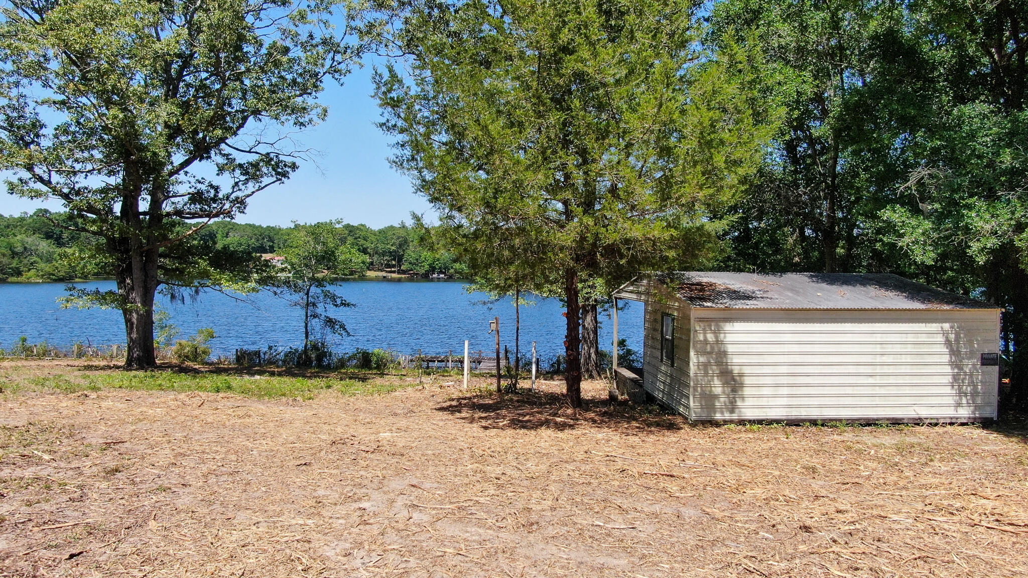 Beautiful appx 1/4 acre lot on Juniper Lake that's cleared, has a dock and a shed that could be made into a little fishing camp. There is also a septic tank, condition unknown. Create your fishing camp or permanent residence! Nice, gentle slope down to the water. Juniper Lake offers an abundance of bass, bream and crappie. Additional 1/4 acre lot next door with paid water tap also for sale: MLS #898329