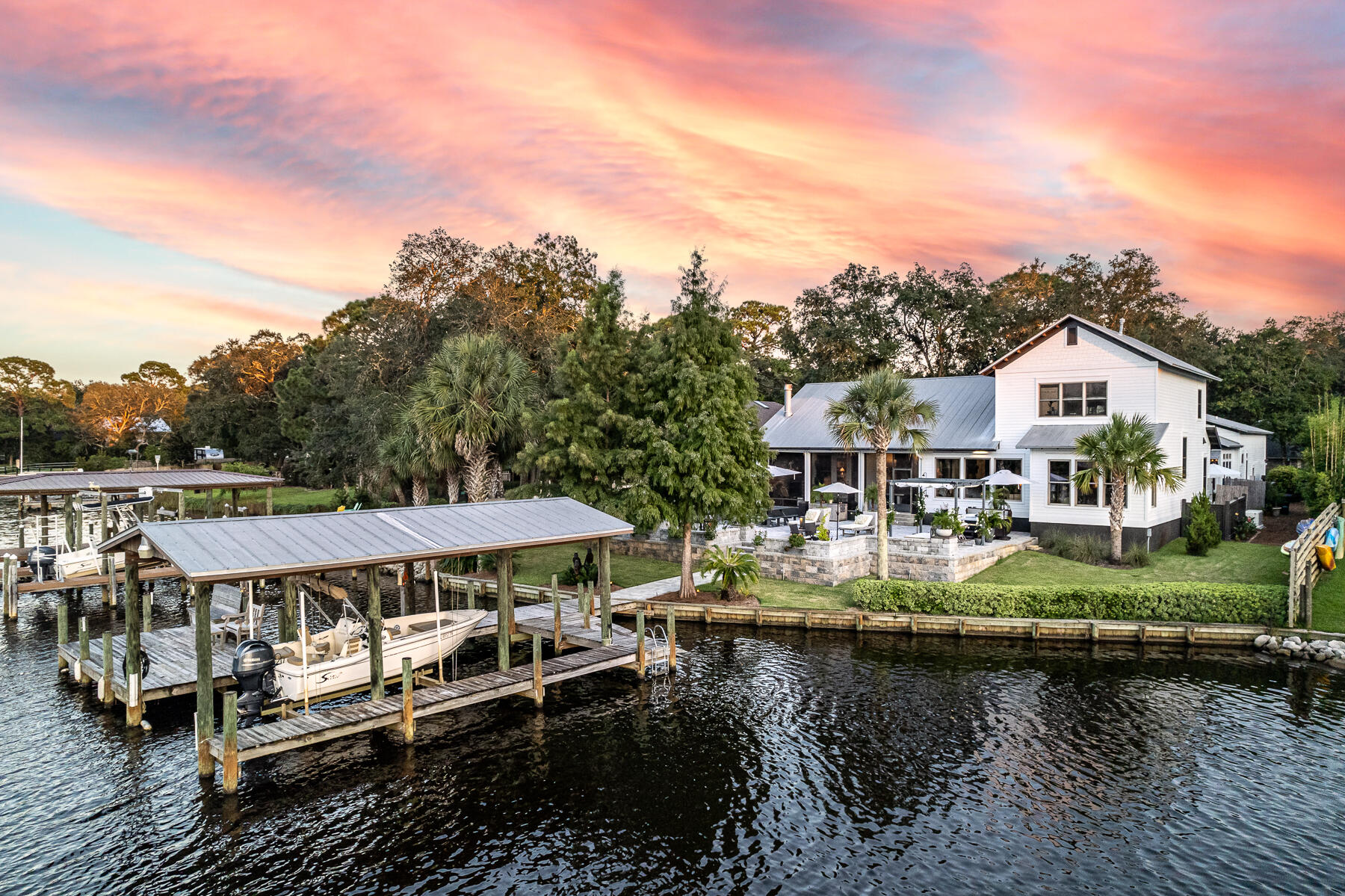 Love boating and entertaining, then this house is for you! Spectacular waterfront home on deep water Buck Bayou, featuring 91 ft of waterfront living with a dock and new lift. This private, gated retreat is tucked away amongst the carefully curated landscaping of the front and yard which is just a taste of what the indoor and outdoor living spaces have to offer. Windows adorn the entire back of the main home on the first floor showcasing the water views throughout. The first floor of this open concept home features the primary suite, powder room, dining room, living room, kitchen and office. Nearby, but tucked away, is a butler's pantry featuring a bar, beverage refrigerator, warming drawer, storage, sink and washer and dryer. The upstairs includes two bedrooms each with their own bathroom The impeccable finishes of this kitchen and butler's pantry include quartz countertops, sleek, contemporary cabinets by Marque featuring soft close doors and built in drawers, high end stainless steel appliances such as Bosch, GE Monogram, & Kitchenaide, pecky cypress accents, shiplap, & stainless hood. Primary suite features a private entrance to the screened porch, shiplap, large windows that allow for lots of natural sunlight and views of the bayou. The primary bathroom includes a soaker tub, large walk in shower, his and her vanities, walk in closet, pecky cypress accents and shiplap. 

The outdoor living space includes a screened porch with a gas fireplace and automatic roll down shades for more privacy and protection. Plus an expansive and inviting pavered patio with grilling station, spa and additional space for dining, conversation areas or just relaxing while taking in the sunset views.

In addition, this home boasts a separate first floor guest cottage attached to the garage. The guest cottage is thoughtfully appointed with a full bathroom, washer and dryer, closets, and kitchen. The kitchen features a small refrigerator with ice maker, dishwasher, microwave and is wired for a stove if desired. The guest cottage is connected to the main house by a quaint pavered courtyard. The two car garage also has a workspace and generous storage upstairs. There is no pull down stairs here, a wide staircase opens to a large open storage area and a secondary storage area that is climate controlled. 

There is no HOA. An extra parking place for a boat trailer or camper. Generator that powers both house and apartment at the same time. Dock has a 4-5 ft draft depending on tide. Owner would consider selling the 2021, 17.5 ft Scout Sport Durado boat and trailer separately for $43,000.