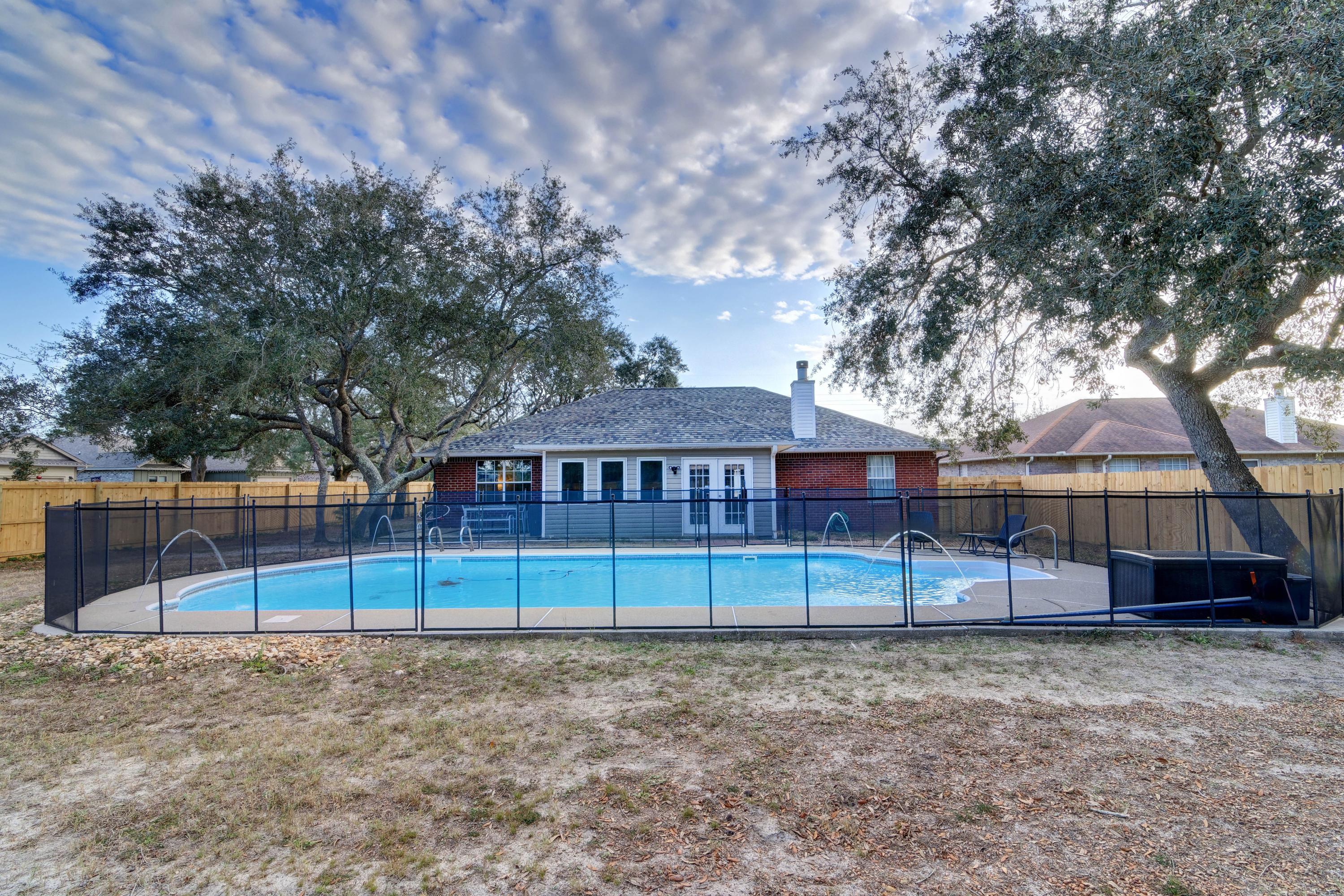 Welcome home to this fantastic all brick POOL home on a massive corner lot in Gulf Breeze ALSO featuring a detached two car garage/workshop! Convenient to local bases and located near the Emerald Coast's beautiful beaches, this updated home provides the best of year round living with an additional living space (not counted in the square footage) found in the tiled Florida room. Drive up the long driveway to enter the home and appreciate the open and split floor plan also boasting a bonus space perfect for an office, formal dining room, or play room. The spacious bedrooms are the only place you'll find carpet, as hard surface floors extend throughout the rest of the house. The relaxing living room has a vaulted ceiling and wood burning fireplace, and along with other upgrades you'll find seller updated lighting throughout. Walk past the interior laundry room to the massive master bedroom, and the owner's suite showcases a master bath with double vanities, two walk in closets, a soaking tub, and separate shower. The other two bedrooms are nice sized with a shared bath. The enclosed back patio has so much character with exposed natural wood, and you'll enjoy relaxing there with a great view of the amazing backyard. Outside you'll find a newly installed privacy fence enclosing the in ground pool (complete with fountains!) which is surrounded by the child safety fence. Enjoy almost a half an acre with another amazing feature - the 2 detached two car garage where the possibilities are endless! Have peace of mind with a roof replaced in 2017 and an HVAC replaced in 2017. You do not want to miss this amazing gem of a home!
