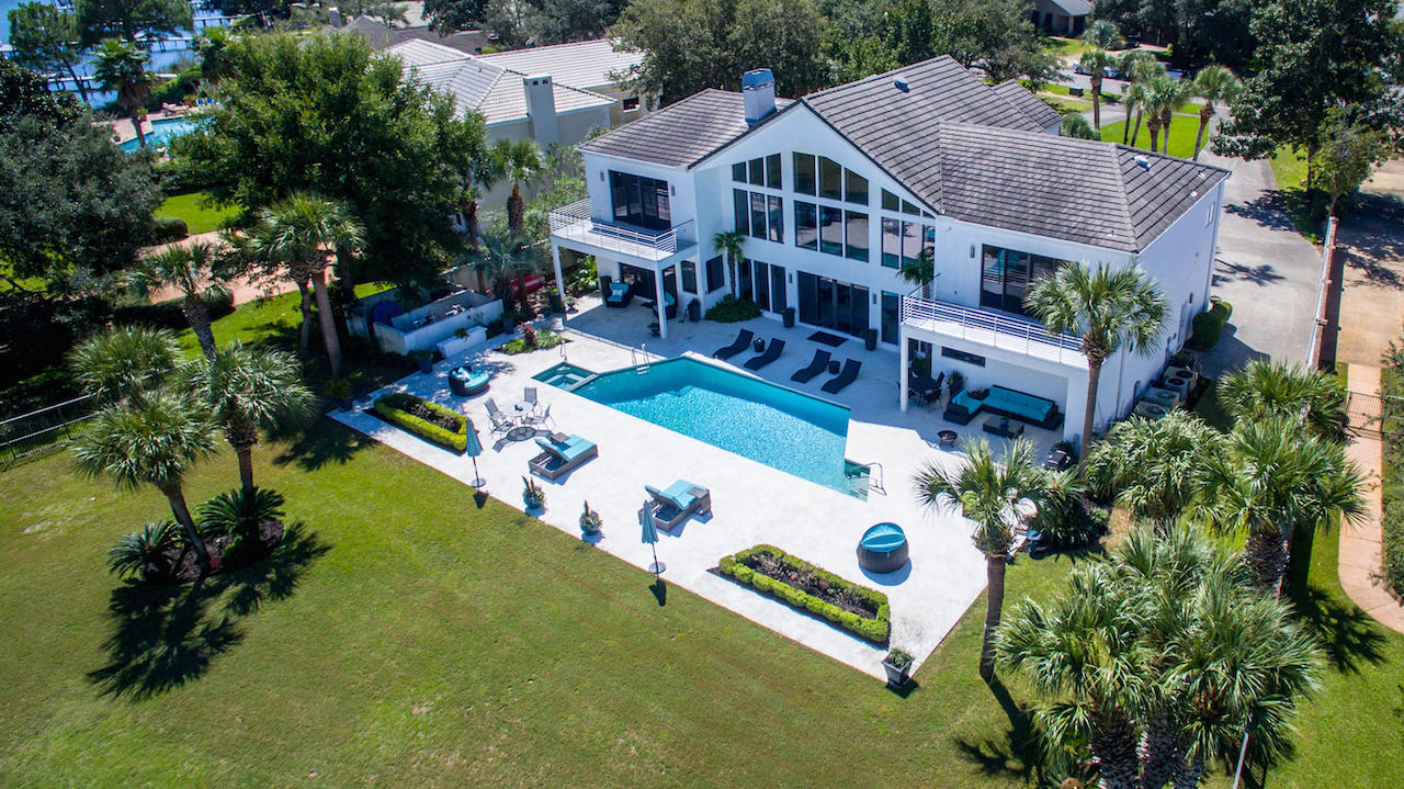 Spectacular contemporary home with 138' feet on deep-water Indian Bayou directly across from Choctawhatchee Bay! This gorgeous residence features a 2+ story wall of windows for stunning water views and abundant natural light throughout. The huge living/dining/bar area is fabulous for entertaining, especially as it leads directly out to the large patio, pool, yard, and boat dock. Impeccably designed, the finishes are beautiful, functional, and decorative. Of special note is the incredible cabinetry throughout the home, which beautifully keeps to the home's contemporary theme, ensuring a clean, minimalistic feel while providing an amazing amount of storage capacity!
The floorplan is perfect for modern lifestyles. Just off the dining area is the fantastic European-style kitchen... ,,,with an adjoining family gathering area and practical computer desk. The kitchen is oriented facing the water, with plenty of natural light. It features a large island, 3(!) sinks, soft-close drawers, both Silestone and granite counters, a large breakfast bar, and stainless appliances including 2 Gaggenau convection ovens, 2 dishwashers (Miele/Fischer Paykel), a Subzero fridge and freezer, Wolf stove, and much more. The bar area includes 2 wine refrigerators, plus cooling drawers, an icemaker, and a cappuccino maker. 

The spacious master suite, located on the first level facing the water, features a gas fireplace, electric privacy blinds, steam shower, 2 sinks and separate vanity with Silestone counters, air tub, separate water closet, and an incredible walk-in closet that feels like an exclusive boutique. An additional bedroom suite on the first floor could easily be used as a home office and guest bath.

The stunning sweeping modern staircase leads to the balcony and 2 upstairs bedroom suites, each with their own baths, walk-in closets including washer/dryer, and balconies. The large sizes could easily accommodate guests or become a bonus/play room and/or large home office. A smaller media/playroom/sitting area is also on the 2nd floor. The current owners converted the garage into a first floor media/family room, but it could be converted back if desired. The home also includes central vac, 8 A/C units, and a paging system, among other conveniences.

The incredible "back" yard offers a large pool, shaded sitting areas, and large sun patio, large lawn, and a boat dock with 2 boat lifts, a jetski lift, fish cleaning station, etc. Ideally located at the entrance to Choctawhatchee Bay, you can easily enjoy all the watersports of the Bay, as well as the Gulf of Mexico--or opt for golfing at Indian Bayou Golf Course. This special residence will make a wonderful home base for years of enjoyment!