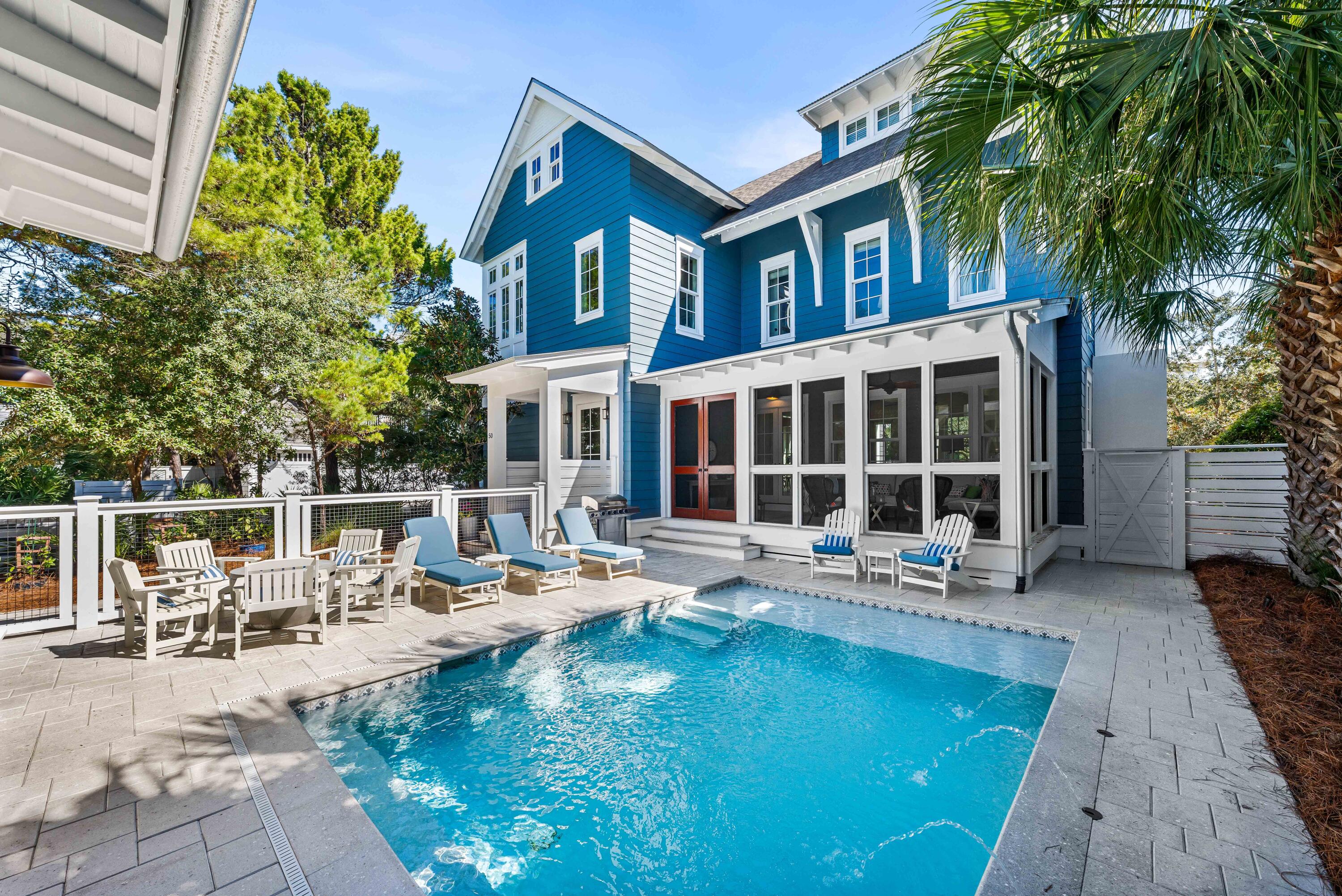Perfectly positioned on a peaceful street in WaterSound Beach, discover this bright and welcoming 4BR/4.5BA residence with over 3,700 square feet, a private swimming pool, a one-car garage plus additional storage space, and ARB-approved carriage house plans from architect Geoff Chick. Step inside to reveal cheerful spaces defined by classic coastal design with reclaimed heart pine floors, gorgeous millwork, shiplap walls, and pops of blue and green gracefully incorporated into the designer furnishings and artwork. In addition, both the interior and exterior of the home have been recently painted. The living and dining spaces flow seamlessly together with coffered ceilings, abundant windows, and a gas fireplace flanked by built-in benches. The kitchen will delight home chefs with custom cabinetry, a walk-in pantry, and professional grade stainless-steel appliances including a separate Electrolux full size refrigerator and freezer and a Jenn-Air six-burner gas range and convection oven. A mother of pearl backsplash complements the quartz countertops including an oversized island with ample prep space and seating for five. The living area opens to a cozy screened porch that leads to the outdoor courtyard complete with pool, sun shelf and water feature.  A custom outdoor cabinet with built-ins, countertop, TV, and beverage fridge services the pool. Two outdoor showers make cleaning-up after a day in the sun a breeze. 
Upstairs, a charming landing space leads to two equally stunning master suites, each with ensuites that feature dual vanities, claw foot bathtubs, and tiled walk-in showers. Both suites have access to a shared screened balcony with hanging bed swing. On the third level, find a comfortable secondary living space and two large bedrooms, each with a private bathroom and one featuring four built-in bunks. With its accommodating design and outstanding location, this property serves well as a primary residence, personal retreat, or investment property. 
Sophisticated and stylish, the gated WaterSound Beach community is located south of Scenic Highway 30A offering homeowners a rare sense of seclusion yet with easy access to area activities. Amenities include swimming pools, a puttering park, community green spaces, a state-of-the-art fitness center, and private boardwalks to one of the most beautiful mile stretches of coastline in the area.