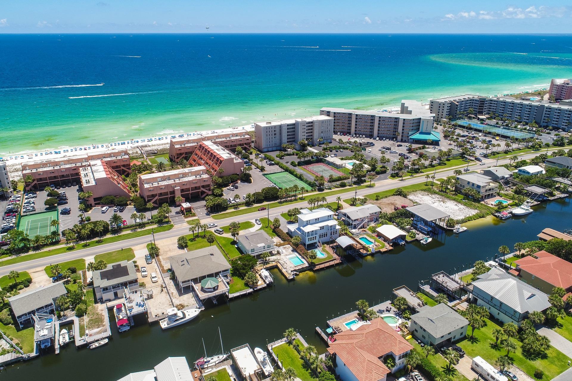 ONE OF THE BEST PPSF IN ALL OF HOLIDAY ISLE! Been waiting for a waterfront home with boat slips and direct access to the prestigious Destin Harbor and beautiful Gulf of Mexico? This is your chance to own a 6-bedroom spacious home with a prime location in Holiday Isle. Experience the coastal lifestyle to the fullest with an expansive entertainment deck including a gazebo service bar & summer kitchen. Take in views of the canal and Destin Harbor from the open deck, relax in the sunshine, or stay cool under the covered balcony. This home is unique not only because it has two huge boat slips on deep water (enough room for multiple boats) but you also have four waterfront bedrooms along with 2 additional guest bedrooms. The beach access is conveniently located just across the street. The upper level has just been updated with brand new wood flooring (high-end laminate) throughout the living & dining area. Beautiful granite countertops were just added with a large breakfast bar, perfect for casual dining. Rooms are spacious and there are waterfront master bedrooms on each level with en-suite bathrooms. There is also a waterfront living area on each level, so this is a great floor plan for a vacation rental or large families. Sliding glass doors throughout the home bring the outside views in for true waterfront living. There is a very spacious two car garage with coated concrete, which maintains well with the elements. Plenty of room to store a golf cart, paddle boards, fishing and beach gear! There are many conveniences near the home like great restaurants, shopping and entertainment options. This is the perfect place to experience all that Destin has to offer including world class fishing, boating, snorkeling the Destin Jetty's and more. Great community with security and minimal HOA fees - only $300 annually. Don't miss out on this great opportunity to own a home with 90 feet of frontage on a deep water canal.