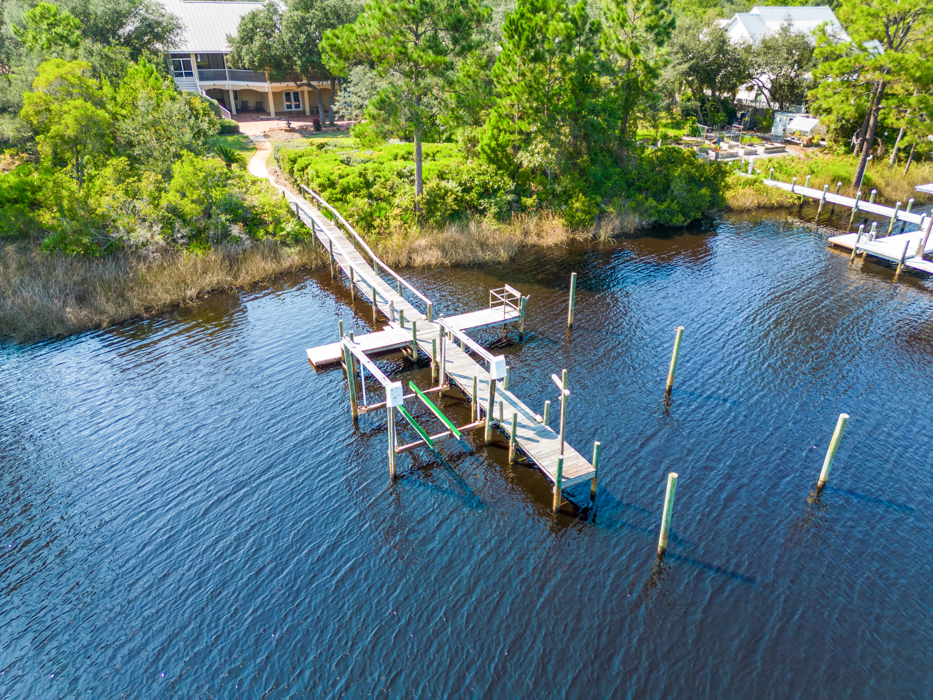 Water front living, exquisite architecture and creature comforts combine to produce a living experience for the most discriminating buyer. Your updates will combine with great bones to produces a one-of-a kind home on the bayou. One full acre of landscaped grounds can be trimmed to reveal a full 100' of frontage on the widest portion of Hewitt Bayou and a private dock with lift. This home's more than 9000 square feet of total living space includes over 2400 square feet of tiled balconies and patios which span the entire length of the home. Water views are maximized from every vantage point. This Sater Home Design custom built home seamlessly blends outdoor and indoor environments. The home's exterior is casually grand in the style of Old Florida living. The home's interior is well crafted with Brazilian hardwoods, unique crown molding, a gas fireplace and a private elevator. Green design includes Geo-Thermal heating and cooling and foam insulation. Doors and windows are high impact glass for reduced insurance costs. A grand entry, gourmet kitchen, wet bar, comfortable family room, private office, water front master bedroom, and two additional bedrooms complete flow seamlessly in the main floor living space. Downstairs is planned for privacy and entertaining with a private entrance, large wet bar, game room, bedroom and expansive patio. A three car garage and separate workshop complete the first floor area. Botany Bayou is a gated, water front community in South Walton County, easily accessible via the Goldsby Road entrance off Highway 98.