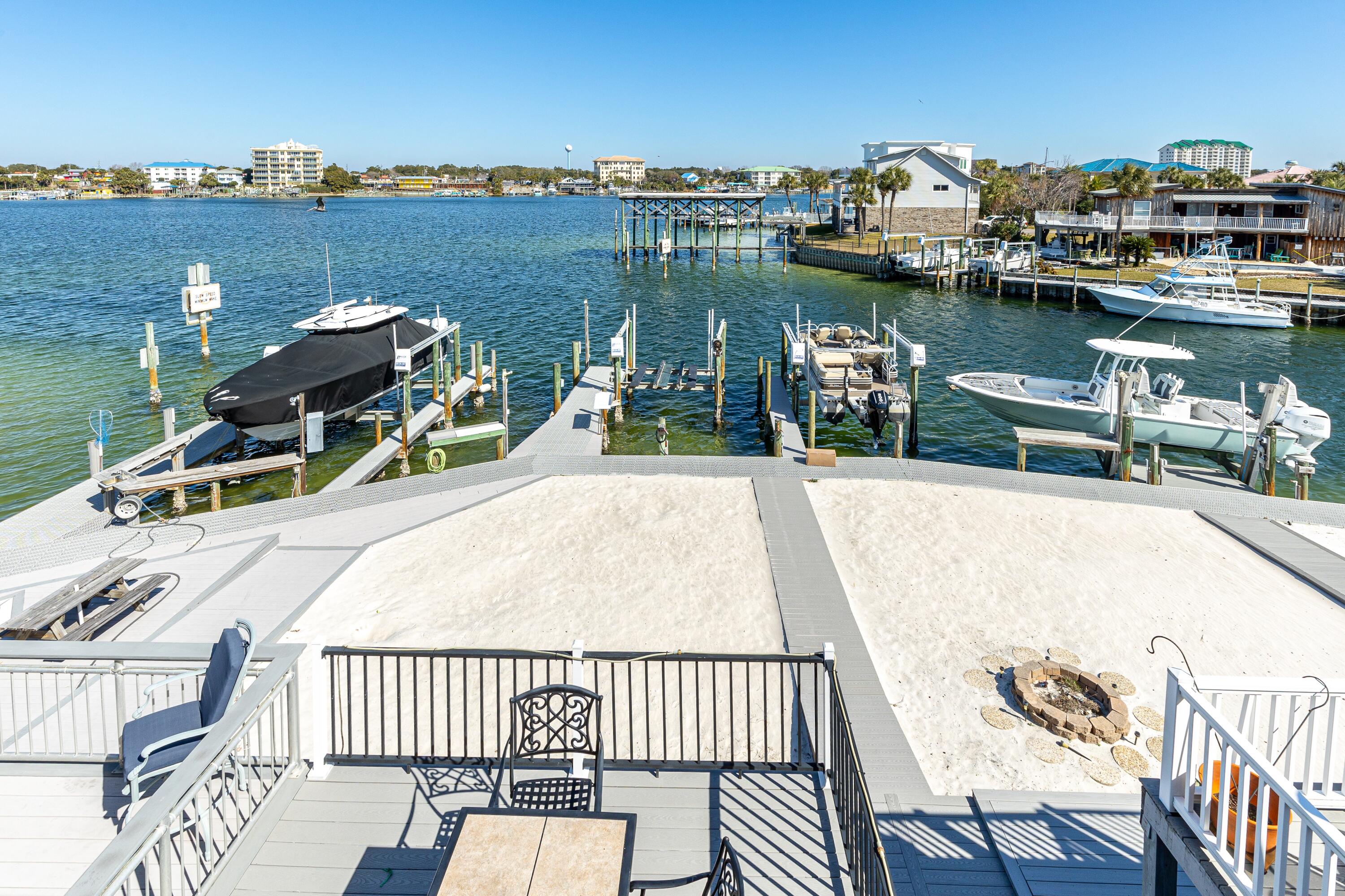 Boaters and beach lovers--this is the one you've been waiting for! Located on Destin Harbor, this beautifully updated 3-bedroom, 3.5-bath townhome features a boat slip and lift that can accommodate up to a 30' boat. Enjoy panoramic views of the harbor from your private outdoor decks. This multi-level home includes a garage, updated kitchen and bathrooms and a new A/C in 2024, making it as turnkey as it is charming. It also comes fully furnished and rental ready, perfect for vacation rental income or immediate personal enjoyment. The vacant lot across the street is available for additional parking. There are no HOA fees for the townhouse and low annual $445 fee for Holiday Isle Improvement Association. Set sail from your private slip or enjoy the harbor views with your morning coffee. The first level features a bunk room that sleeps four and includes a bath. The second level offers great views from the living room and kitchen.  The third level boasts the harbor-front primary suite and bath, as well as a guest room and bath. This is coastal living at its finest. Schedule your private showing today!
