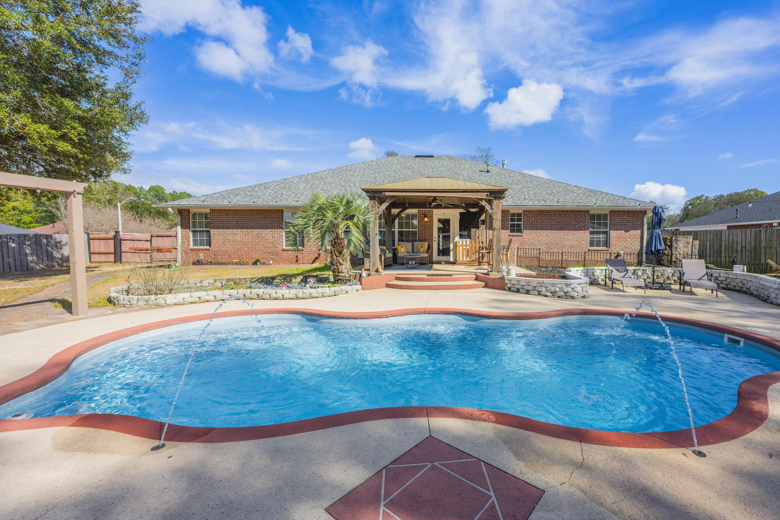 Welcome to this exceptional pool home, perfectly situated on a sprawling half-acre corner lot in the well-established Gardenbrook neighborhood! With its classic brick exterior, two-car garage, 5 year old roof, 6 year old HVAC system, this property will offer peace of mind for years to come. Inside, you'll find 5 spacious bedrooms and 3 bathrooms thoughtfully designed for comfort and privacy. High ceilings and a cozy fireplace create a warm and inviting living room. The kitchen is the heart of the home featuring granite countertops, an island, an abundance of cabinetry, and a breakfast area. Right off the kitchen is a spacious formal dining room. Just off the kitchen and living room, the Florida room is perfectly positioned for seamless entertaining and relaxed indoor/outdoor living. A conv eniently located bathroom near the Florida room provides easy access for pool guests. The split floor plan provides a private retreat in the oversized primary suite, complete with a tray ceiling and en suite bathroom. Enjoy a double granite vanity, dual walk-in closets, a separate shower, and a soaking tub designed for relaxation. Additional bedrooms are thoughtfully tucked into their own hallways and corners of the home, offering space and privacy for family and guests alike. Step outside to the backyard oasis! The gunite pool invites you to unwind under the Florida sun, while the expansive yard still leaves plenty of room for gardening or play. A covered pergola offers shaded relaxation during summer days, and a large shed/workshop adds valuable storage and workspace. A mature live oak enhances the charm and provides welcome shade. In addition, the home also has a whole house generator and a sprinkler system. This is Florida living at its finest! Space, comfort, and the perfect setting to make lasting memories.