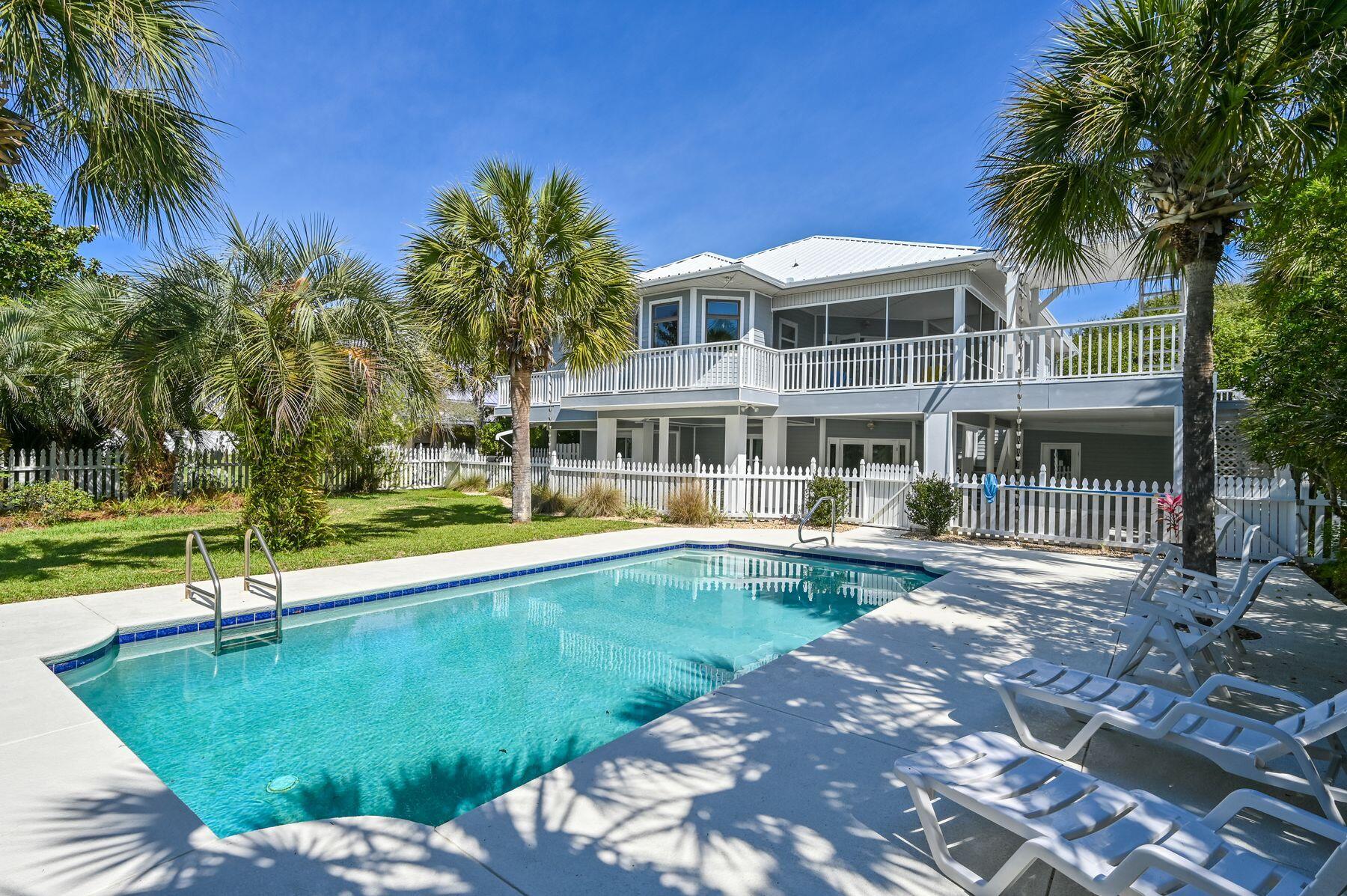 This property is all about space, privacy and old Florida charm. Set well back from the road, this property has a an extra-wide driveway leading to two garages but that's just the beginning. As the house comes into view, you'll appreciate the lush setting with gulf views from the front deck. Set on almost a half-acre, the private yard features mature palms casting shadows across the 32-ft. saltwater pool and sun terrace. A gate provides deeded access to the white sandy beach. Inside, the octagonal 26-ft. living room is on the second floor, providing expansive open living space with pine wainscoting beneath an airy tent-style ceiling. It's a comfortable space designed for gathering and engaging with family and friends. Sliding doors provide access to the generous balcony and allow sea breezes to waft gently indoors. Tile floors connect the sitting and dining areas with the separate kitchen, which includes a table and a host of new stainless appliances. The best spot for breakfast is perched on stools by the bay window, enjoying the amazing view. The master suite is also on this level with a private bath, closet storage and balcony access. The shady wraparound porch offers a generous area for alfresco dining and entertaining. Climb the steps to the lookout for dramatic sunset views over the treetops to the shimmering Gulf of Mexico. Two further bedrooms and another bath and half bath complete the second floor. The first floor has a large covered terrace for outdoor living. A white safety fence separates it from the beautiful private pool and lush yard. There's a second kitchen, two more guest bedrooms, a bathroom with laundry and a second sitting room. It could easily be converted into a separate unit for independent family members or used as a rental opportunity. One of the garages has a dehumidifier and the other has air conditioning and heat, providing useful space as a workshop or storage. The property has been well maintained with a top-grade metal hip roof and hurricane straps. Standing at 19.5-ft. elevation, flood insurance is not required. The home has hurricane shutters and aluminum panels and passes wind mitigation.