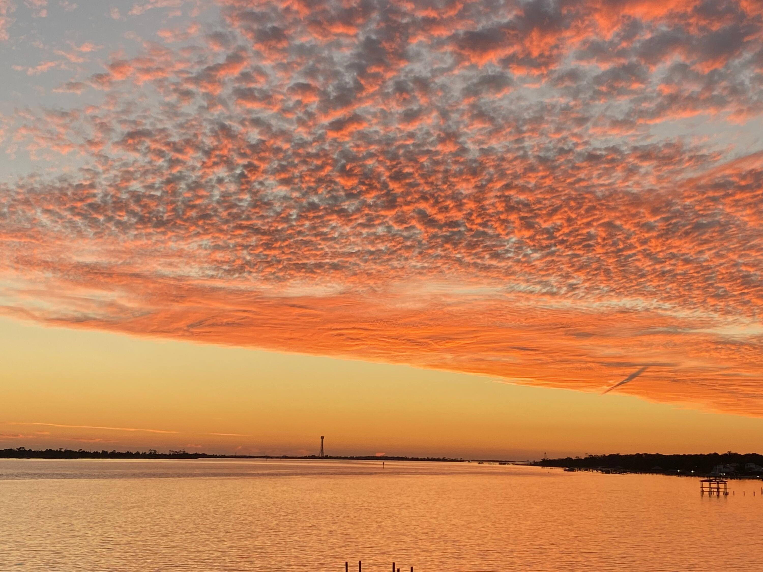 Sunsets, sunsets and more perfect sunsets!! Welcome to this beautiful waterfront getaway. This 3 Bed 2.5 Bath, 1,534 sqft condo is quite a find in this area. The unobstructed view is an even harder find. Year-round sunsets, waterfront pool & deck, dock slip with boat lift, the list goes on! Throughout you will find a fine wood textured porcelain tile. Wake up and step out onto the balcony with this exquisite view every morning. Condos can often have the issue of never having enough space for storage, not here! The space is cleverly put to use including a MASSIVE primary closet through the bathroom, large utility room with washer/dryer, kitchen with pantry and large outdoor storage. The large open living space with kitchen and wet bar is the ideal entertaining space for family and friends.