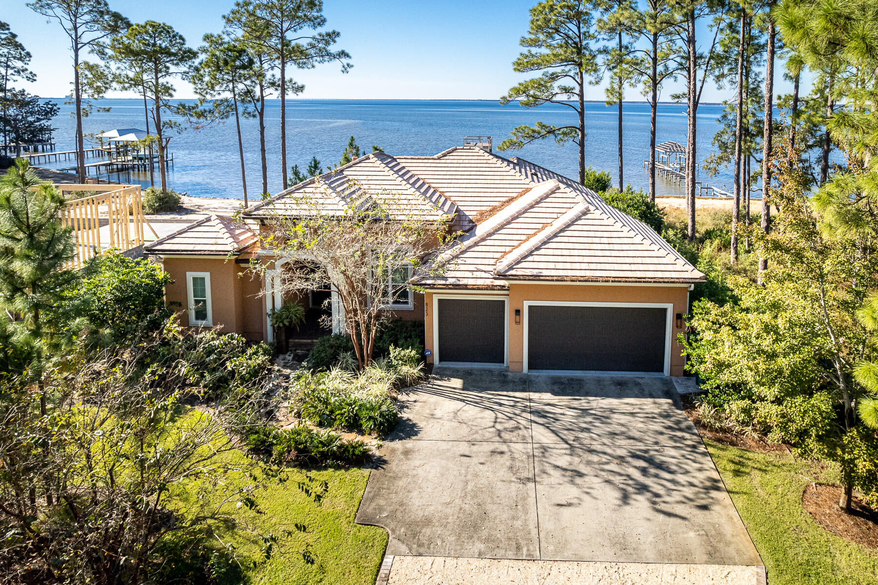 Bayfront living conveniently packaged in this charming, immaculate, manageably-sized estate home. Only minutes from Sandestin Resort and Grand Boulevard shops and dining, Driftwood Point Road is a renowned area for Bayfront living. This custom Arthur Rutenberg (Coquina Model) waterfront home has a stunning western facing view of the Choctawhatchee Bay and is perfect for someone looking to enjoy both indoor/outdoor living and year-round sunsets. Those breathtaking views invite visitors from the dramatic wood and glass front doors all the way through the fully retractable glass patio doors. Offering designer modern furnishings (included), custom features, and plenty of space, this home is perfect for entertaining. Rustic meets modern in the chef's kitchen which was updated in 2018.  The upgrades include stunning custom cabinets from Marquis Kitchens, a unique waterfall quartzite countertop, a Mercury 48" induction cooktop with two ovens and separate broiler, and a striking externally vented custom range hood. The Sub Zero refrigerator, Wolf microwave drawer, bar/coffee area, and Asko dishwasher combine for an entertainer's dream. 

With three bedrooms, in-home office and 2.5 baths, you'll have all the room you need for your family to grow with plenty of space left for entertaining guests. Privately positioned in the split floorplan, the master suite frames bay views and includes Bayfront lanai access. The recently remodeled modern master bath includes double sinks, heated flooring and towel warmers - perfect for relaxing after a long day. Plantation shutters are found in all bedrooms which provide privacy and natural light. 

Step outside and imagine lounging by your heated BADU swim jet salt water pool surrounded by butterflies, while you enjoy the lush locally sourced landscaping and privacy this home has to offer. The outdoor lanai is spacious with seating and dining and is protected by a recently replaced screen enclosure and Coolaroo Shades. 

The dock was rebuilt in 2021 and a beautiful new two-level deck was added with space to launch a kayak and paddle board. You'll love the panoramic views from the upper deck or on the patio while sitting in front of the fire pit.

Perks of this residences include one of the few houses not in HOA, a gated lot, a whole house water filtration, a Ronco full-house generator, security system with cameras, an entertaining butterfly sanctuary, and remote sunshades.