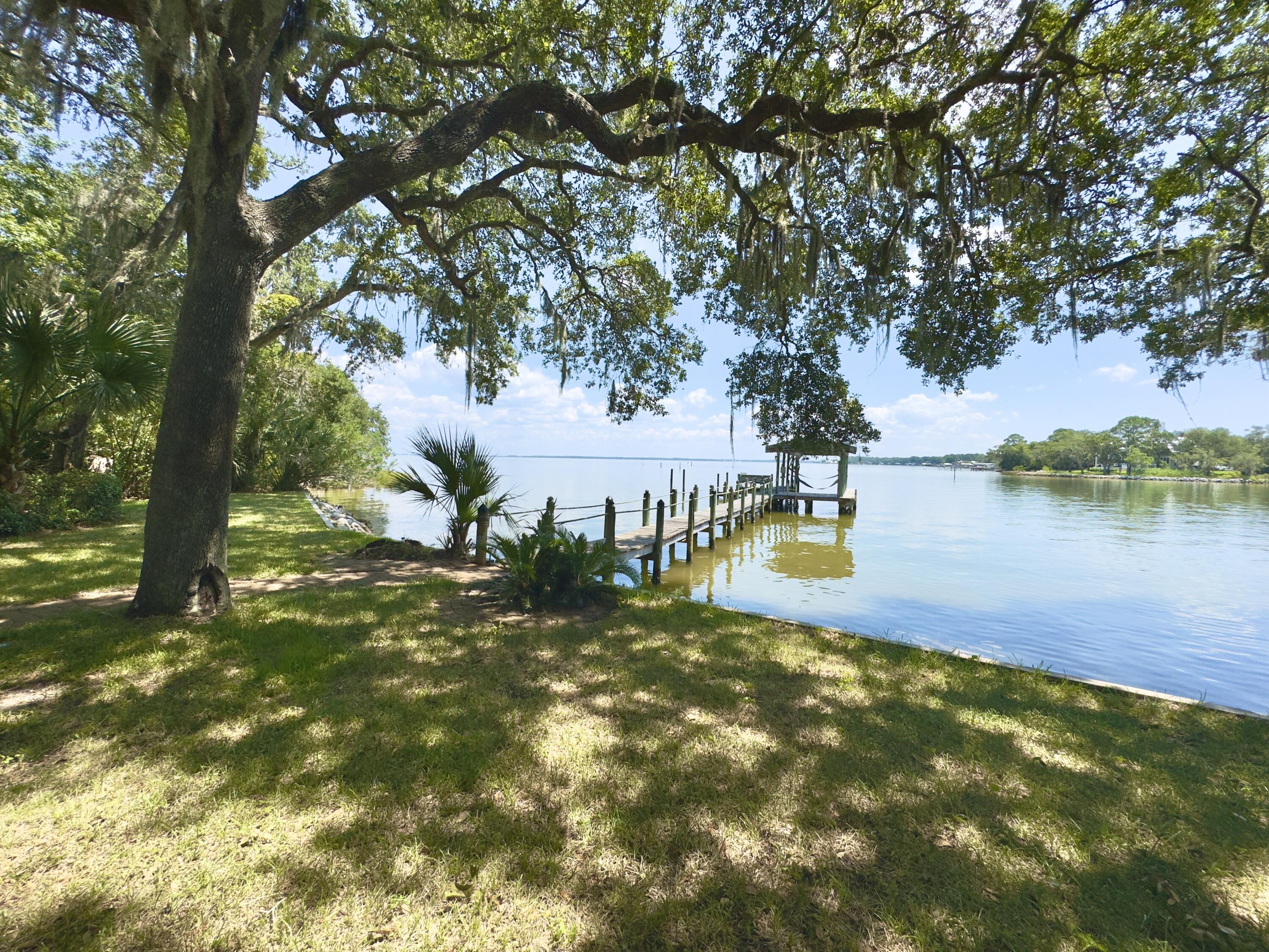Looking for an exquisite All-Brick home situated on a premium 3/4 Acre Private lot on the Bay? Here it is! This property also includes a detached 2-car garage w/studio/guest room/workshop built in 2018. It is heated and cooled with a full bath & 2 automatic garage doors - perfect for a business owner, car enthusiast, artist, you name it! The garage doors have automatic screens that roll down so you can enjoy the breeze flowing without the pesky bugs. 

The views are breathtaking, the home is solidly built all-brick w/hip roof (new in 2021); Dual A/C units, whole house & building Generac generator. 

4 bedrooms with primary suite on the main level. Bedroom #2 has en suite bathroom and doors directly to the screened porch and back yard to take in the morning sunrise and evening sunset. The Upper level 4th bedroom w/en suite, kitchenette & balcony overlooking the water. The 3rd bedroom on the main level has direct access to a full bath via a pocket door. The kitchen includes a large center island with an ice machine; two garbage compactors; and tons of counter space. Large laundry room with cabinets and closets for storage and access to the garage. The list goes on and on! Call your favorite REALTOR to schedule a showing at this one-of-a-kind property.