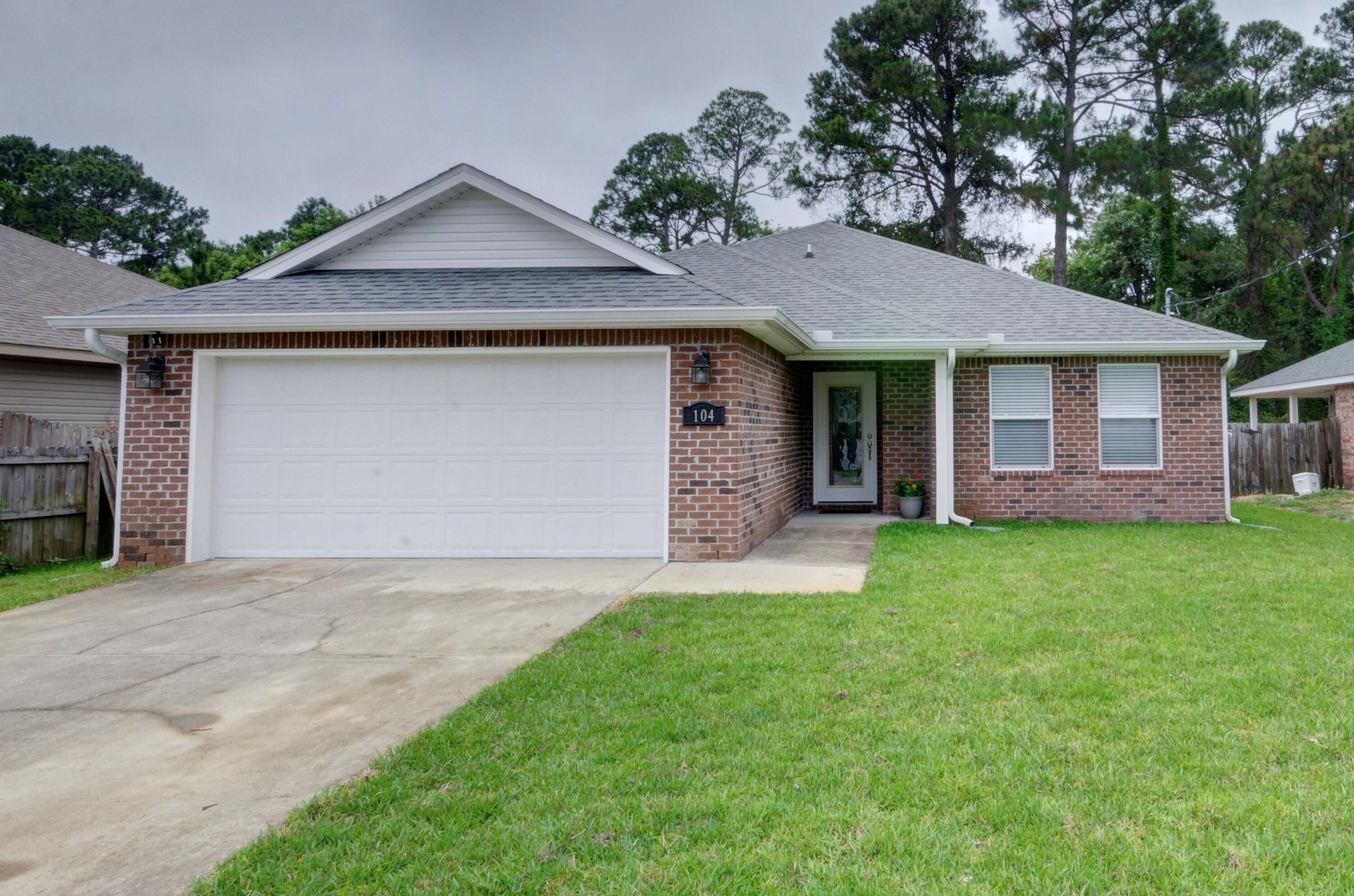 Welcome home to this move in ready 3 bed/2 bath brick beauty just minutes to Hurlburt's front gate! Drive up and start by appreciate the brand new landscaped yard (new sod in the front and backyard), and walk up to the beautiful glass front door. Inside you'll find ceramic tile throughout (carpet is only in the 2 guest bedrooms), and freshly painted walls! The long entryway leads to a split floor plan where to the right you'll find two nice sized guest bedrooms with a shared bathroom. The open floor plan features a large living room with crown molding and recessed lighting which leads to the eat in kitchen space and then the well appointed kitchen. Showcasing custom cabinets, granite counters, stainless appliances, a separate pantry, crown molding, and drop down pendant lighting over the kitchen bar, you're going to love this space! The spacious master bedroom is located off the living room and is fully tiled, and has a fantastic owner's bathroom featuring double vanities with matching cabinets and granite counters (the same as the guest bathroom as well!) along with two separate walk in closets and a private water closet. Walk out the brand new back door (with built in blinds) and enjoy relaxing on your covered back patio overlooking your fully fenced in private yard. The property behind the house is US government owned, so you'll enjoy the privacy of not having backyard neighbors! The yard is fully irrigated with a sprinkler pump, and the house also features gutters, and interior laundry room, and a 2 car garage. Washer and dryer will convey along with Ring doorbell.