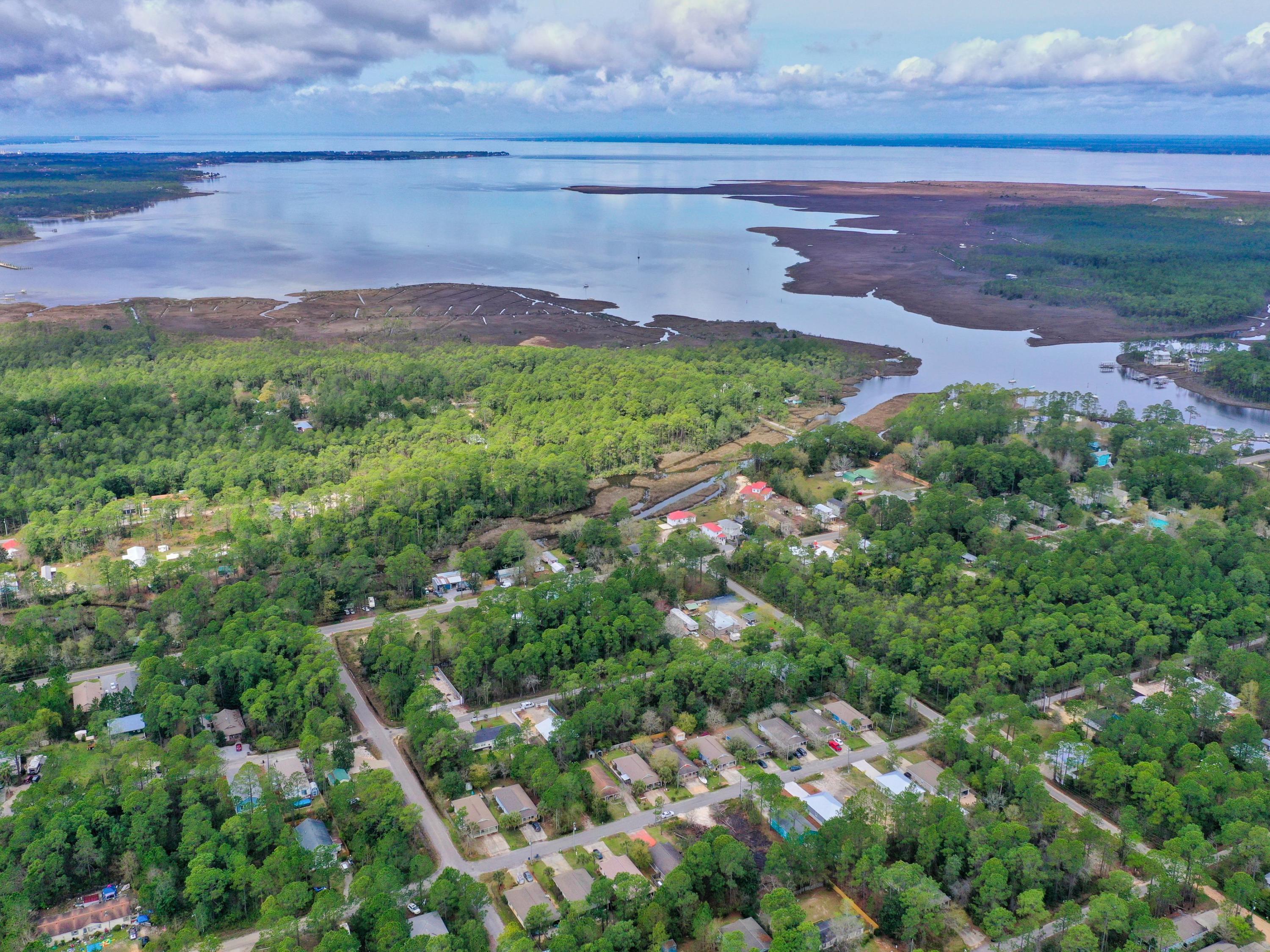 This attractive level lot with tall trees is ready for your dream cottage, near the exciting Florida boating and beach lifestyle. Located equidistant between Cessna Landing and Boat Launch and the shimmering emerald green waters of the Gulf of Mexico and pristine sugar white sandy beaches, the lot is in a quiet neighborhood. Covered picnic tables, a scenic boardwalk and view deck over water on the bayou and a neat playground for little ones offer fun outdoor activities in walking distance. Single story cottages line the street where an air of simplicity blends with the feel of nature and cost of reasonable. It's a great first home opportunity as well as the chance to downsize and embrace a very uncomplicated way of life in your own new home sanctuary.