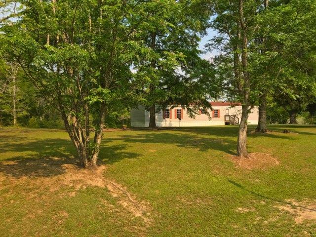 A BEAUTIFUL PIECE OF PROPERTY WAITING TO BE CALLED HOME! This parcel has a single wide mobile home that is well kept and perfect for a first home or live in while you build that dream home! The mobile is very nice and would make a lovely home, BUT the real gem is the property... 13 acres with it's own private pond! Only wet areas are around the pond, plenty of high and dry land for building. Seller replaced the HVAC unit within the last month, no repairs are needed that we are aware of at all. Huge back porch overlooking the pond and property makes for a private oasis to enjoy the morning coffee or evening sunsets. Take a look and make this your country home!!