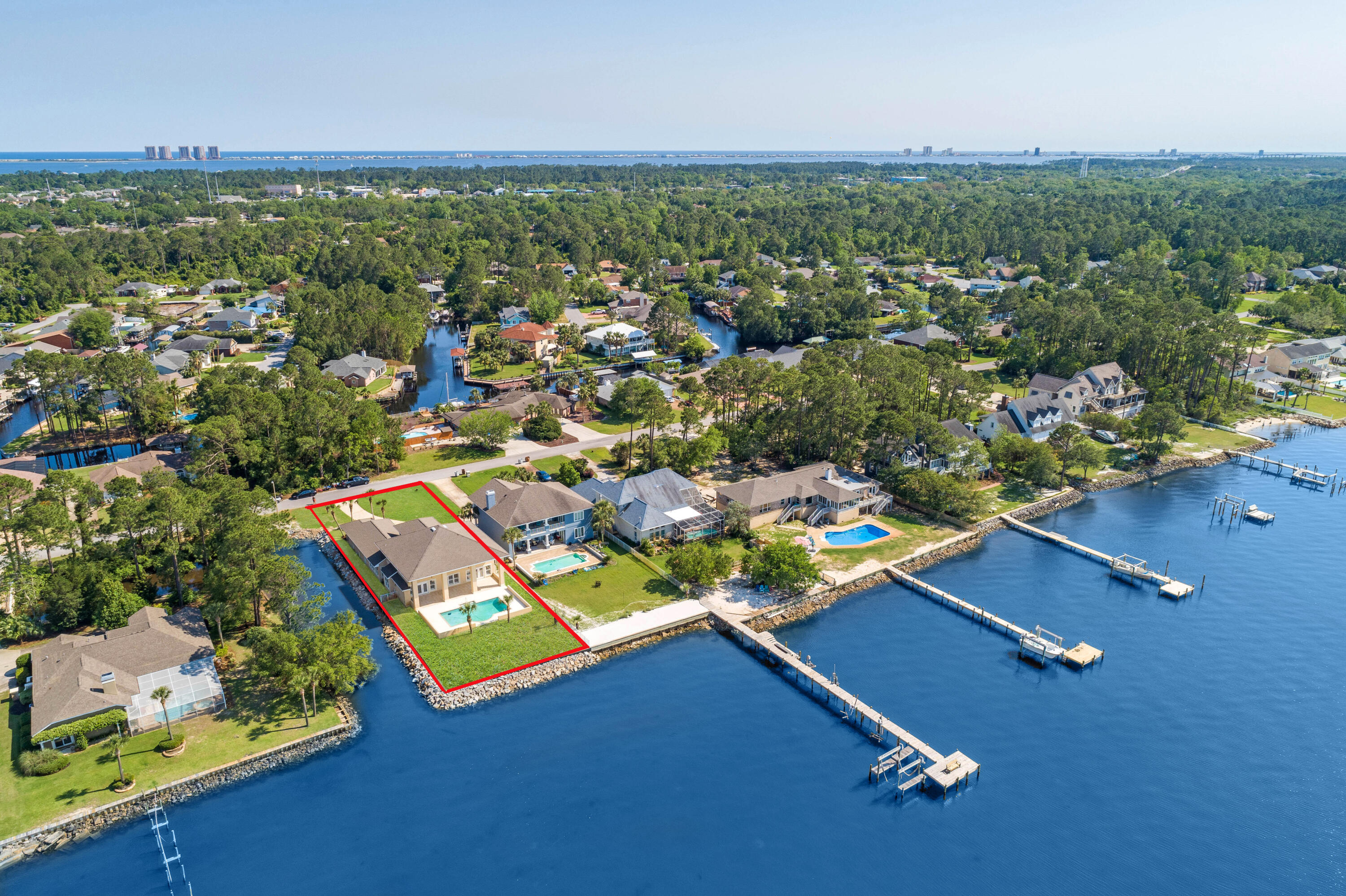 This regal waterfront estate resides on Pensacola Bay and offers a gunite pool with a 3 car garage and an open spacious living area. Embrace the ample natural light that floods into this gorgeous home with stunning water views from the entire living area. Ideal for entertaining, this home offers a sizable kitchen with a  formal sitting/entertaining area, formal dining room and covered lanai (47'x14'). Enjoy the resident dolphins that frequent the area daily and relax and enjoy epic sunsets from your backyard oasis. The kitchen comes equipped with custom cabinetry with pull out drawers, granite countertops, a plethora of cabinet storage and counter top space, double wall oven, 5 burner electric cooktop, prep sink, built-in desk and walk-in pantry. The primary suite has a separate entrance t o the lanai, dual walk-in closets and the bathroom has a walk-in shower with dual shower heads, garden tub, his-and-hers vanity with linen storage and a water closet. Upstairs you'll find 3 bedrooms and 2 bathrooms. Two bedrooms share a Jack-and-Jill bathroom and the 3rd bedroom makes for a great guest/in-law suite with a massive walk-in closet and bathroom with a walk-in shower and garden tub with abundant cabinet storage and water views. Other notables are BRAND NEW irrigation well and pump, plantation shutters, crown molding, over-sized laundry room with additional storage and utility sink, powder room for guests, additional  storage room in garage, pull down attic stairs, termite bond, hurricane protection, fenced back yard, child safety gate for pool, eve lighting and exterior ring camera. 160 tons of rip rap just added. Flood insurance is $550. Located in Gulf Breeze school district and just 7 miles to beautiful Pensacola Beach. Check out our full video tour on the MLS and YouTube.