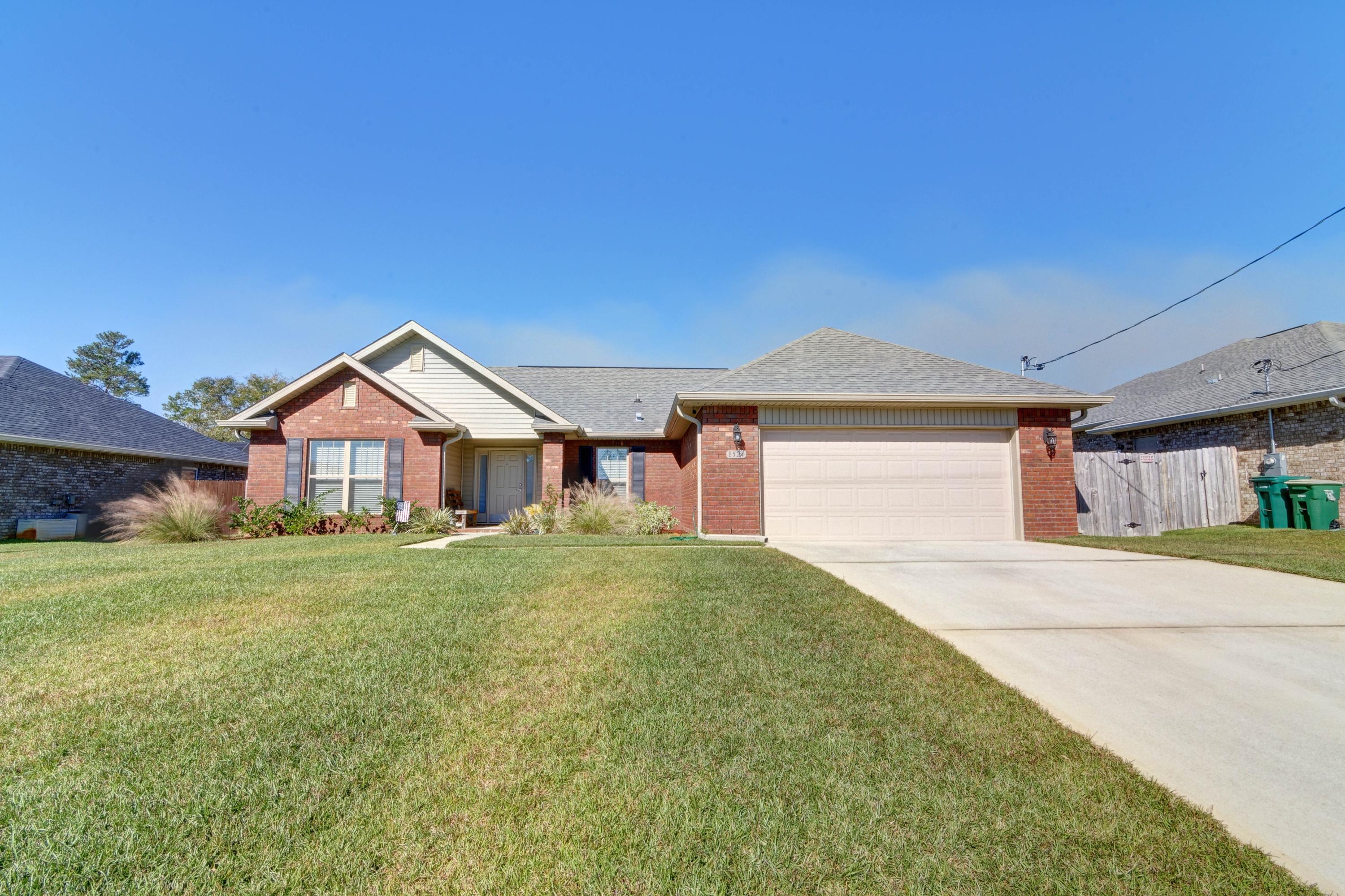 Welcome to this stunning open concept home that features 3 bedrooms, 2 baths, plus an office space on a quarter acre lot in the desirable neighborhood of Holley Hills! Pull up in the long driveway and appreciate the tasteful landscaping, which will lead you to the covered front porch and inside to enjoy soaring 10ft ceilings. Natural sunlight pours through the multiple windows of the spacious living room with hard surface flooring extending throughout (the only carpet is found in the bedrooms), and it's open to the gorgeous and fully updated kitchen. Custom cabinets with granite countertops and stainless appliances are showcased in the kitchen, and you'll love the massive kitchen island with tasteful pendant lighting. The eat in kitchen leads to the back door where you'll find a covered back patio and the fantastic fully fenced in backyard complete with a large storage building. The large master bedroom features a trey ceiling and an en suite with double vanity marble countertops, as well as a separate shower, soaking tub, and walk in closet. The split floor plan has two additional bedrooms and a nice sized guest bathroom on the other side of the house, and off the living room you'll find a great office space tucked away. The interior laundry room is located off the two car garage. Don't delay in snagging your spot in this amazing neighborhood with a short commute to Hurlburt Field and close to Navarre's beautiful beaches!