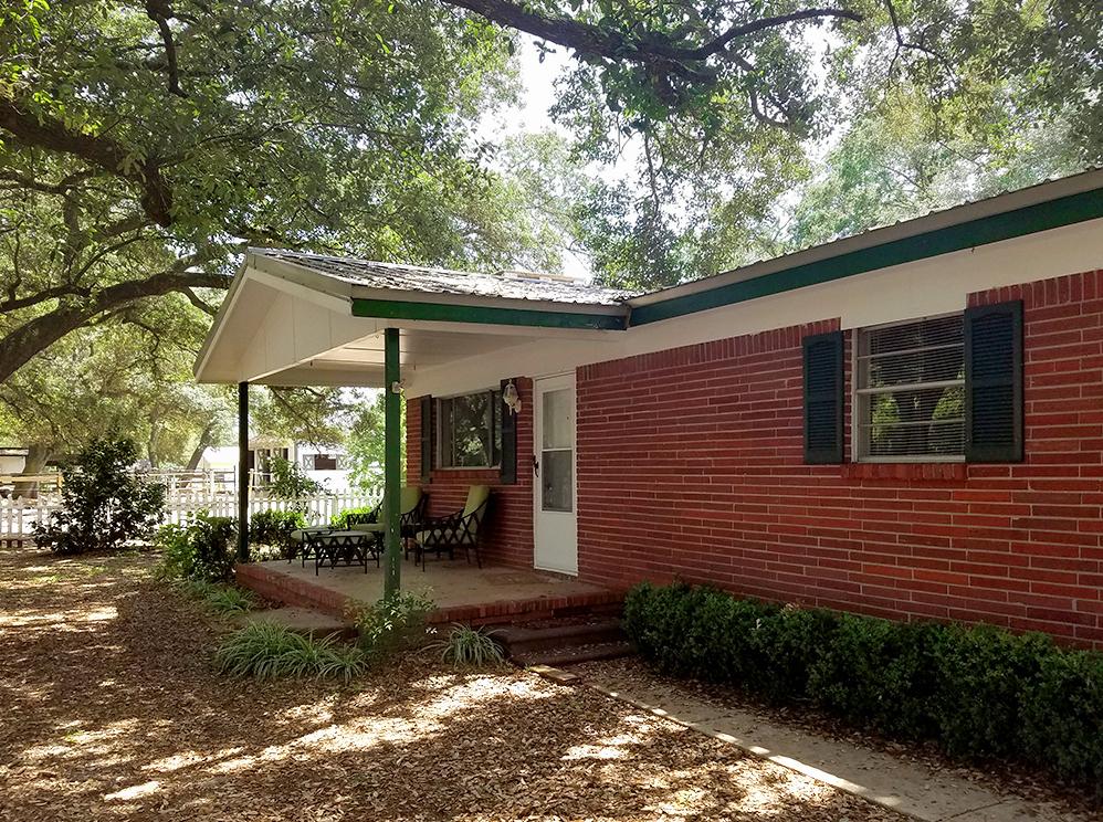 Rare and beautiful property with stables, land, and a home located near the Blue Water Bay area of Niceville, FL just off of HWY 20E. This 1.83 acre property is perfect for a private equestrian estate, boarding facility, or development. This well-maintained, all brick home features 3 bedrooms/2 baths with 1774 sq ft and a large screened-in patio overlooking the main barn and paddock area. A new metal roof and HVAC system were installed in the past few years. The kitchen opens to a large den and a second living area with a gas fireplace. The kitchen also features a gas stove/oven, microwave, dishwasher and refrigerator. The master bedroom is very spacious and has an en-suite bathroom with a walk-in closet, tub/shower combination, and two separate vanities. There are two additional bedrooms with a full bath. The home features a split and open floor plan! Enjoy coffee in the morning while relaxing in the under roof, screened patio which overlooks this beautiful horse property.  The main barn (45x45) was built in year 1997 and features a hay loft (20x45) for approximately 300 bales of hay, hay elevator,  4 oversized stalls with private paddocks attached, a feed and tack room with wash bay and on-demand hot water. The accessory barn has 4 separate stalls with private tack rooms and paddocks. There are also 4 additional outdoor wash/tack stalls, a 40 foot shaded pen, full size riding arena, a shaded chicken coop and goat pen!  The accessory barn features a full bathroom and office space. The horse arena has a clay base and was repacked and graded for property water run-off (2016). Stalls feature rubber mats custom made for the space, some fans, and automatic water. This property is currently being used as a therapeutic riding lesson facility. Property has two septic tanks and public water. Come see the many large, majestic oak trees, the beautiful horse facilities, and the home!  Buyer to verify all information and dimensions. This property is uplands, Flood zone X, and zoned R-1.