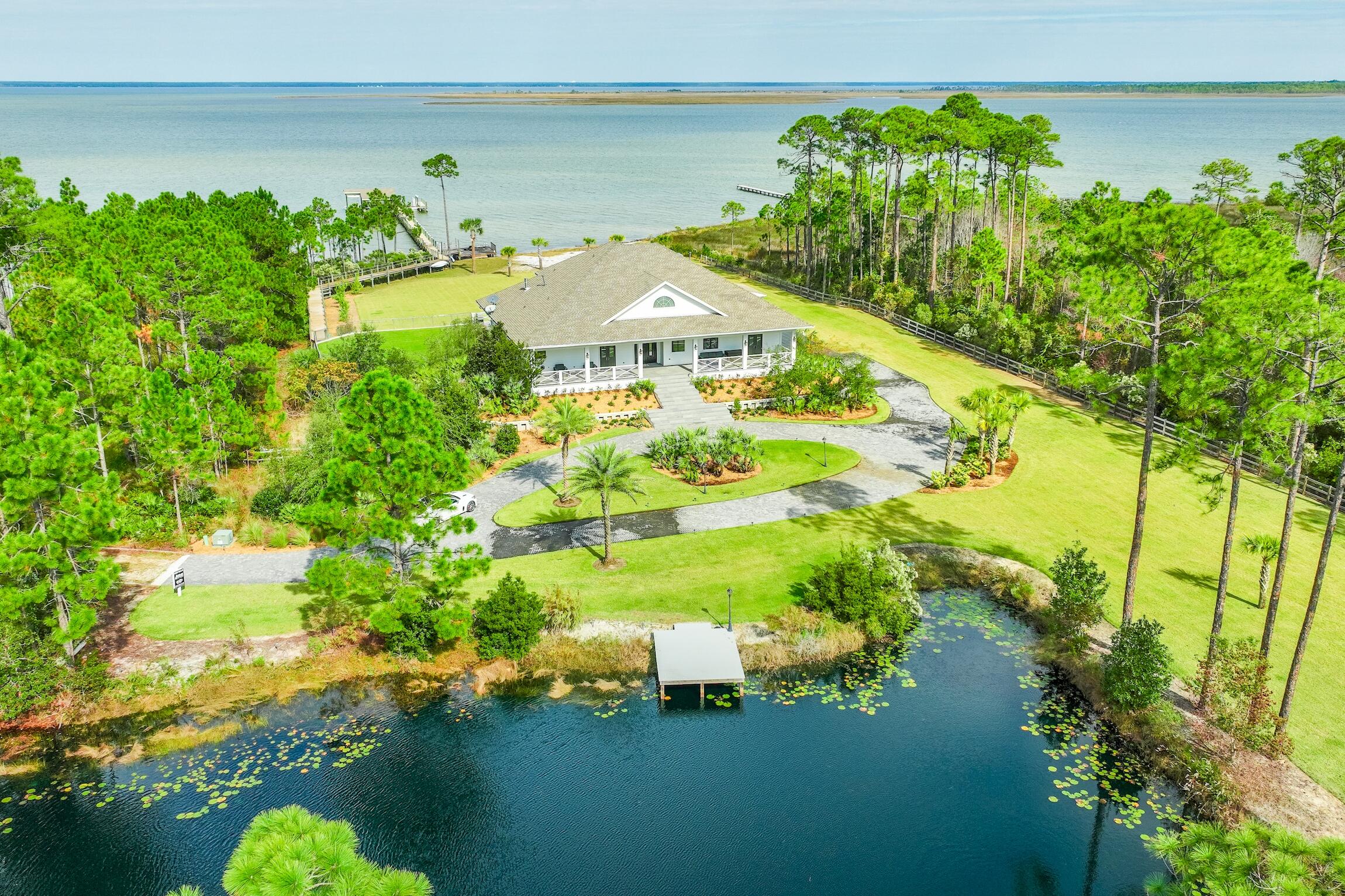 Rare Find! Incredible Estate on the Bay perched on 3.38 acres with 240 feet of Choctawhatchee Bay frontage, this fully renovated 6-bedroom estate offers over 5,700 sq. ft. of luxurious living space and unparalleled privacy. Outdoor living is a true highlight, featuring a brand-new heated pool, spa, and pool deck, plus a 250-foot dock with two boat slips, tropical landscaping, and even a stocked pond with bass and brim for fishing and relaxation. Enjoy complete seclusion with this gated home surrounded by nature while still being just one light away from Scenic 30A and Gulf-front Topsail State Park. The home's Florida room is an enclosed entertainment haven with raised wood ceilings, glass surrounds with panoramic views, added pool bath and seamless access to the new pool deck. Inside, thoughtful renovations and elegant finishes abound. The main level features solid wood cabinets, new porcelain tile floors, shiplap, 10' ceilings, and stone accents. Glass sliders and large Pella windows bring the serene outdoors inside. A chef's kitchen with state-of-the-art Viking appliances, Quartz countertops, wet bar, prep kitchen, and temperature-controlled wine room (holds ~1,200 bottles) is ideal for entertaining. A formal dining area overlooks the Bay with sliders to the Florida room, while a spacious living room features a modern electric fireplace paired with abundant natural light, picturesque views and cozy atmosphere. The first-floor master suite is a coastal retreat, boasting shiplap accents, a sitting area, private lanai with an electric fireplace, two walk-in closets, and a spa-like bath with a clawfoot tub, walk-in shower with four shower heads, and herringbone tile floors. The east side 1st floor bedroom provides a second master essentially with a separate French door entry to the front patio. This room is large enough for two queen beds and offers a beautiful ensuite bath. There is an additional room by the entry with double doors and wood walls that is an ideal office or can be a true bedroom with a bathroom right across. The oak staircase, highlighted by an elegant chandelier, leads upstairs to three additional bedrooms, each with an ensuite bathroom. Two of the bedrooms are Bayfront, each opening onto a spacious balcony with breathtaking views. Ample storage, two laundry areas, and a two-car garage complete the home.

This home is uniquely perched on a high elevation with a marine grade seawall below the home surrounding the entire property for added protection. Additional features include hurricane protection, two new HVAC systems, a whole-house generator, zoned irrigation, two new commercial tankless hot water heaters, an alarm system, surround sound, new exterior lighting, expansive backyard, and new deck boards for the 250-foot boardwalk and dock. With no HOA, this is a truly one-of-a-kind private oasis offering ideal coastal living.