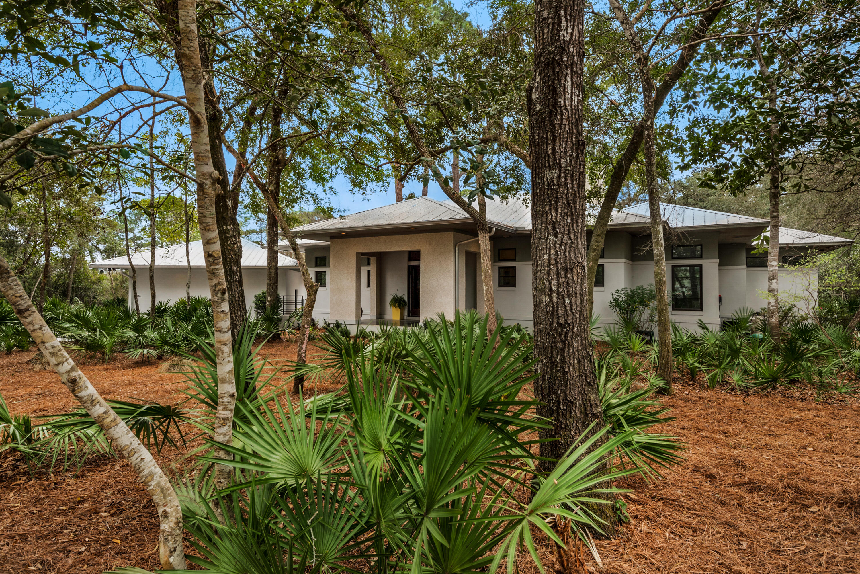 Moored behind acres of never-to-be-developed state forest awaits a home showcasing contemporary living in an elegant bay-front gated community called The Estuary. The neighborhood is approximately 10.5 feet above sea level, with lush indigenous vegetation exuding nature's inspiration throughout this intimate community of only 39 homesites. Minutes away from the blue-green waters and white sandy beaches of 30-A and Grayton Beach, The Estuary is a treasured haven. 176 Ansley Forest Drive is an exquisite one-level, three-bedroom/two-bath residence on a quiet cul de sac across the street from the bay and community dock, where enjoying beautiful sunsets with expansive bay views will become a daily ritual. This quaint masonry style (ICF constructed) contemporary gem timelessly reflects the perfect harmony between clean lines, modern simplicity, and a daily connection with nature. The sublime screened-in porch offers enhanced privacy given the conservation easement and is usable year-round. The adjacent exterior deck is delightful for outdoor dining and relaxing by the fire pit in the cooler winter months. There is a detached wood-paneled two-car garage with covered steps to the main house. The home's interior boasts Brazilian walnut flooring throughout, a vaulted great room ceiling, a wood-burning fireplace, and a modern kitchen with a gas range, stainless steel appliances, granite countertops, and custom cabinetry. The open floor plan creates an effortless flow that beautifully maximizes the use of space, while French doors leading to the exterior porch infuse the interior with the serenity of indoor/outdoor living. The master suite is cradled against an exuberant woodland backdrop making it a cozy retreat. The ensuite features his and her vanities, a custom-built walk-in closet, and a glass-front zero-entry walk-in shower. Masterfully crafted 8-foot doors grace the adjacent bedrooms and hallway. Take this rare opportunity to call this property home.