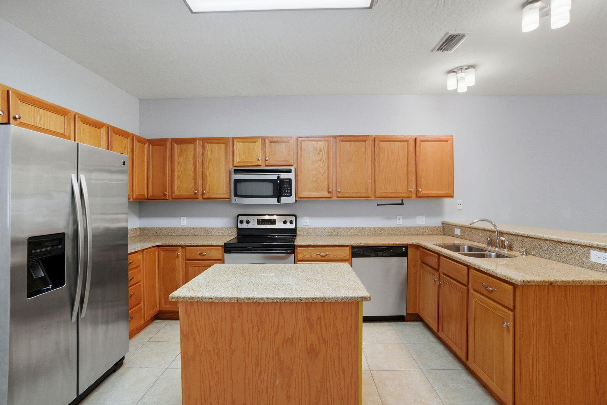 This two-story townhome features an open-concept layout perfect for everyday living and entertaining. The kitchen is the heart of the home with granite countertops, a center island, stainless steel appliances, and plenty of solid wood cabinets for storage. Tile floors flow throughout the main level while plush carpet keeps the bedrooms cozy. Ceiling fans help keep those Florida energy bills in check. The two-tone paint with chair rail molding adds a nice touch of character. Upstairs you'll find spacious bedrooms with good closet space. Convenient half bath on the main floor plus storage under the stairs for all your extras. A covered back porch lets you relax outside after a day at the beach, which is just a short drive away.  Close to beaches, bases, shopping, and restaurants!