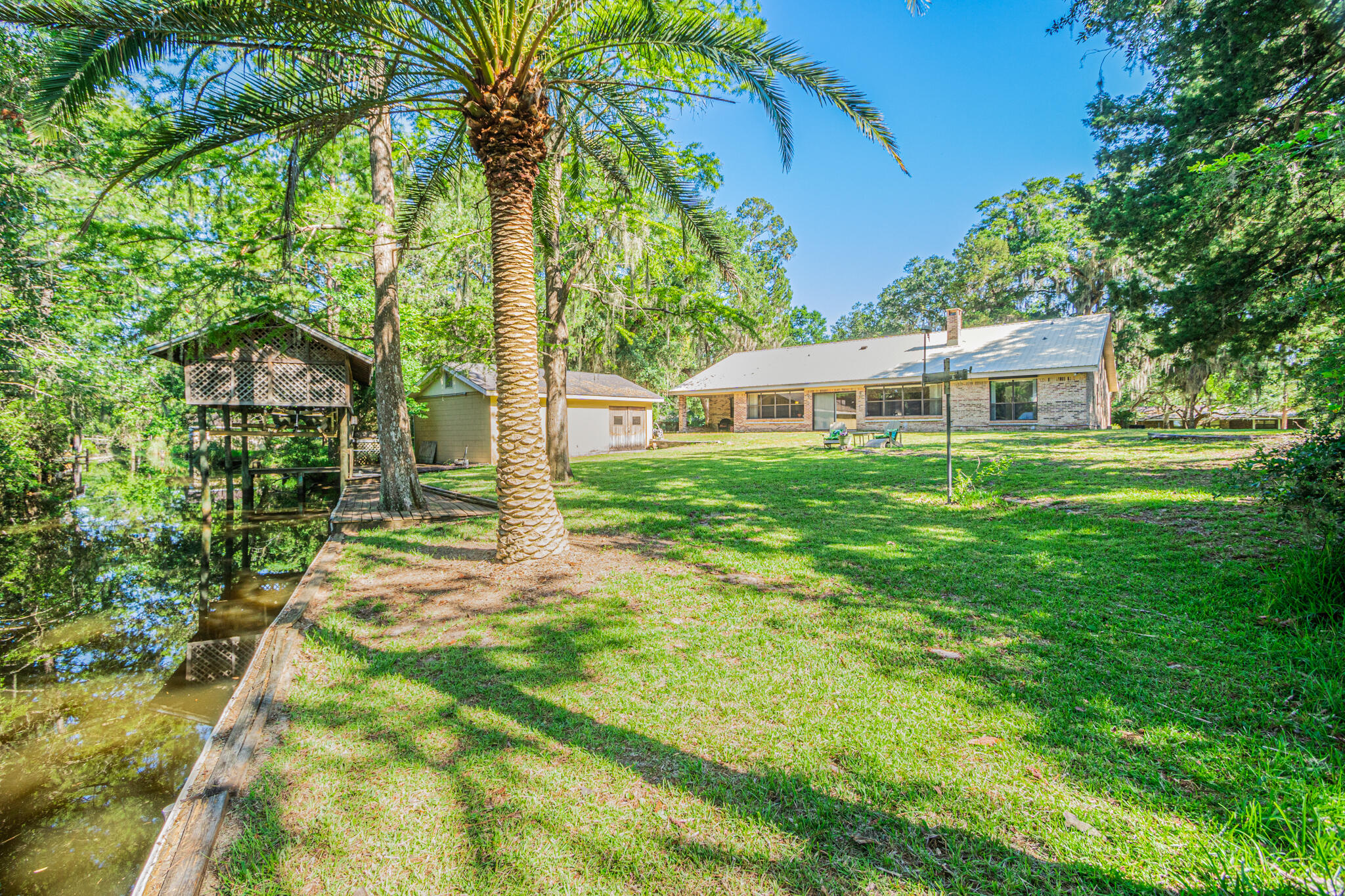Lovely Jolly Bay waterfront home offers an incredible coastal living experience, that's unforgettable! This lovely 3-Bedroom, 3 bath, all-brick ranch style home with metal roof is situated on .45 acres amongst the beautifully landscaped yard fill with oaks, saga palms, azalea's, a palm tree and a circular drive.  It's complete with a picturesque boathouse setting, a dock and a large workshop.

Welcome to this very well-kept Grande home with emphasis placed on the gathering places throughout the home being large and spacious from the formal dining /family rooms to the living room, the large kitchen and out to the Florida room. Plenty of space for everyone to spread-out and have lots of 'elbow room' to spare.     

The kitchen is filled with an abundance of solid wood cabinet and lots of counter space and is equipped with windows offering views of Jolly Bay.  The split floorplan has sizeable bedrooms on each end of the home (each with an ensuite), laundry room down the hall just before entering the oversized double car garage. This garage has a wall full of solid wood cabinets, wood shelving, small work bench and tool storage.  Note: Kitchen appliances will remain as well as washer/dryer.

The Florida room is an extraordinary space that can be utilized for many indoor-outdoor living spaces with a covered patio at the end.  The homeowner loved this room due to its tranquil setting. Countless hours accumulated over the years that were spent painting, reading, enjoying morning coffee & making an abundance of great memories.  The home was oriented with all the rooms located on the backside of the home overlooking the waterfront allowing folks to wake up to bay living!  

It boasts of a 540 sqft (18' x 30') workshop complete with power & water.  It is the perfect place to store all your fishing gear & tackle, yard equipment and tools, etc located right next to the dock & boatlift (boat not included).  Bring your boat to store in the boathouse, ready to embrace and explore the multitude of navigable waters in this region from Jolly Bay, Black Creek, the Choctawhatchee Bay with its' many bayous or head right to Crab Island or the Gulf of Mexico all setting the stage for incredible watersport, fishing, swimming, and boating opportunities.

Not only does this bayfront sanctuary provide a peaceful and private retreat, it is also conveniently located close to all that South Walton County has to offer from the white sandy beaches of Florida's Emerald Gulf Coast (beach lover's dream) to exploring local nature preserves & natural habitats, array of the finest shopping and restaurants from casual to fine dining,  entertainment and so much more!! It's the best life living in Florida's Panhandle!

The solid bayfront home offers a wonderful canvas to dream, dreams and make many incredible memories here! Let's get started.. this home is waiting for you to make it your own!!  Call to check it out today!  

Metal Roof - 2017
HVAC Jan 2024
Electrical Panel box updated Feb 2023
H/W & plumbing updated Feb 2023

Notes:  
There is a sprinkler system, however, it is not currently working. The seller thinks it may have been frozen during winter and does not intend to repair it. Being sold "as is".

There is a stain on the workshop doors.  That is from rainwater coming down & hitting the door, not flood waters.  Per the owner, flood waters have only come up to the edge of the workshop, but never made it inside.

Room and lot dimensions are approximate. Buyers responsible for verification of all information of importance.