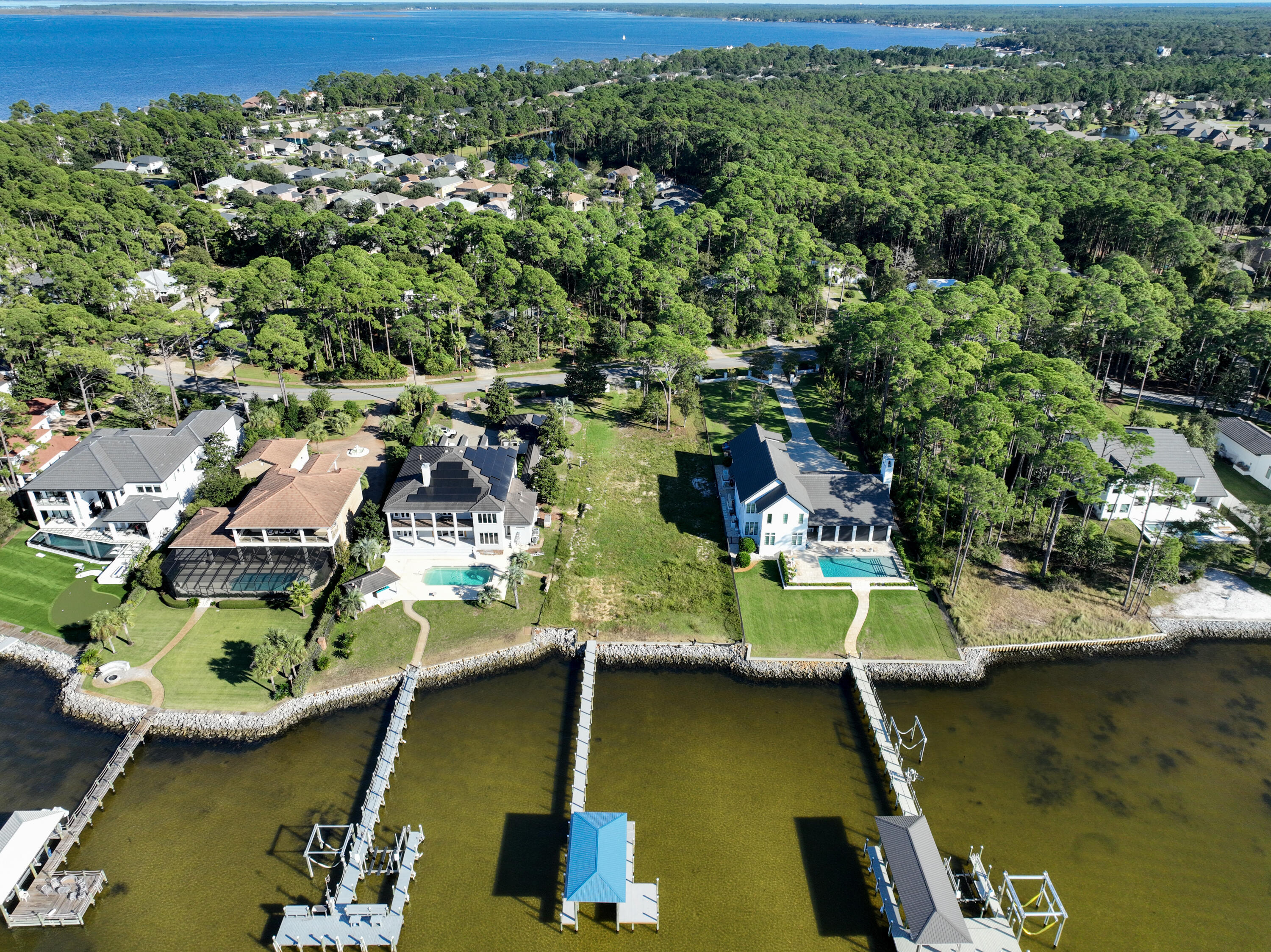 This exceptional, nearly one-acre estate sized lot boasts an impressive 100 ft of bayfront in South Walton's most sought-after waterfront community. Positioned perfectly to capture the breathtaking west-facing sunsets, this property offers a rare combination of location, space, and readiness for your dream home. With a brand-new boat lift and dock already in place, you'll enjoy immediate access to boating and water sports. The lot is fully cleared, prepped, and a permitted set of architectural house plans, significantly accelerating the building process—potentially saving you up to two years of time and effort, are available. Imagine unwinding in your custom-built home with sweeping bay views, private waterfront access, and daily sunset vistas. Whether you want to catch trout and redfish off the dock or enjoy watching the dolphins play, opportunities like this don't come often. Schedule a visit to see this remarkable lot today! Water and Sewer Impact Fees Have been Paid. Boundary and topographical surveys and a full geotechnical analysis are available.