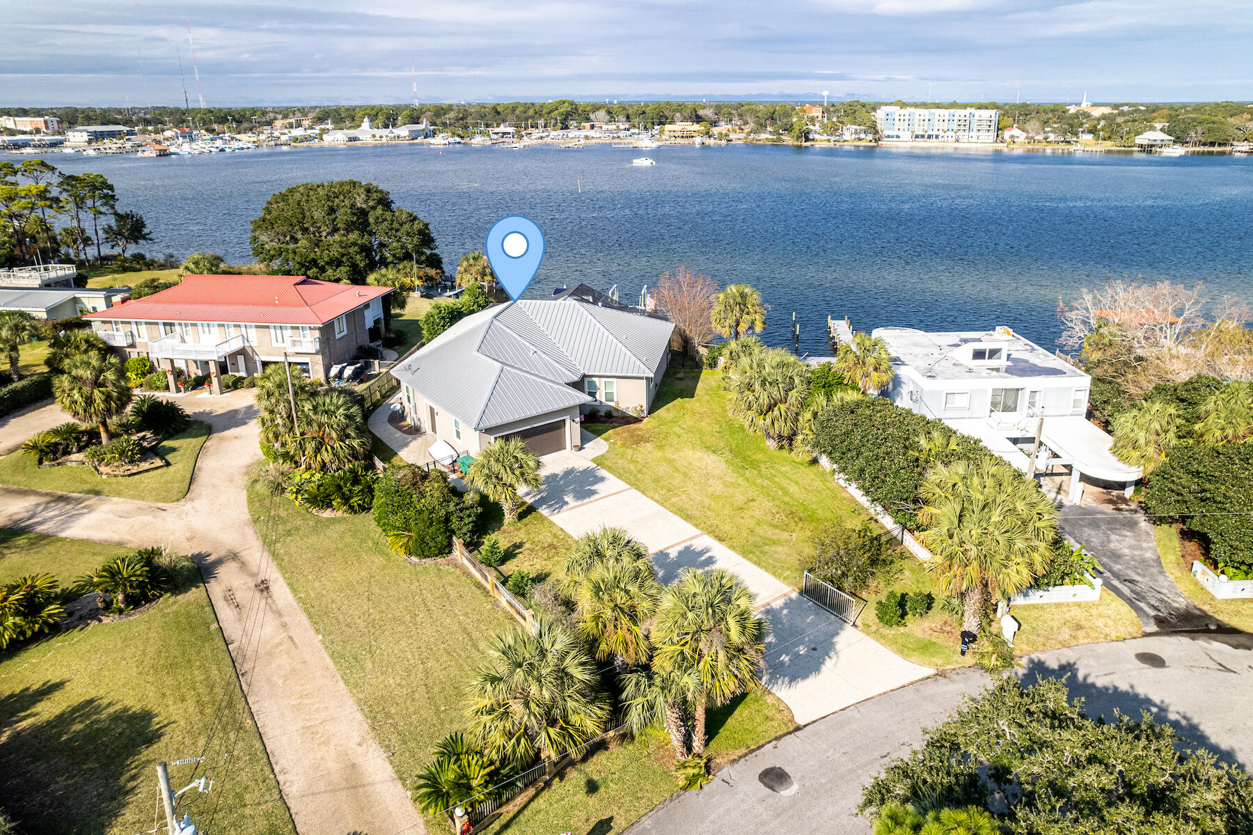 This exceptional waterfront estate resides conveniently on Okaloosa Island and offers 88 feet of Sound front footage and comes equipped with 2 boat lifts/jet ski lifts (20,000 and 16,000 pounds built by Frank Davis of Davis Construction). With outstanding craftsmanship and built with Insulated Concrete Form construction (which ensures low insurance), this home offers a screen enclosed heated saltwater pool and spa, additional garage for a golf cart, and commercial ice machine. With a wonderful flow and open spacious floorplan, this home make the perfect place for entertaining guests. The kitchen comes equipped with custom cabinetry and soft close drawers providing ample storage with pull out drawers, 6 burner gas hood range cooktop, prep sink, water filtration system, wall oven and built-i This exceptional waterfront estate resides conveniently on Okaloosa Island and offers 88 feet of Sound front footage and comes equipped with 2 boat lifts/jet ski lifts (20,000 and 16,000 pounds built by Frank Davis of Davis Construction). With outstanding craftsmanship and built with Insulated Concrete Form construction (which ensures low insurance $1503 annually), this home offers a screen enclosed heated saltwater pool and spa, additional garage for a golf cart, and commercial ice machine. With a wonderful flow and open spacious floorplan, this home make the perfect place for entertaining guests. The kitchen comes equipped with custom cabinetry and soft close drawers providing ample storage with pull out drawers, 6 burner gas hood range cooktop, prep sink, water filtration system, wall oven and built-in TV with under cabinet lighting. Enjoy water views from the entire living area as well as the primary suite located on the first floor. The living room has double sliding glass doors and the dining area has sliding glass doors providing ample natural light. The primary suite also has sliding doors to the covered patio with Sound views right from the bed. The primary bathroom offers a double vanity, garden tub and separate walk-in shower. Other notables are METAL ROOF, water and cleaning station located on the dock, Rainbird sprinkler system, gutters, under eve lighting, keyless entry, stone pavers encompassing the pool, outdoor sink, private outdoor shower, gas fireplace, security system, tankless gas water heater, oversized laundry room with sink and additional storage and one level living. Just a short walk or golf cart ride to the public beach access and the Gulf of Mexico a quarter mile away. Come and enjoy all the Gulf Coast has to offer and enjoy countless sunrises enjoying your morning coffee watching the boats go by.
