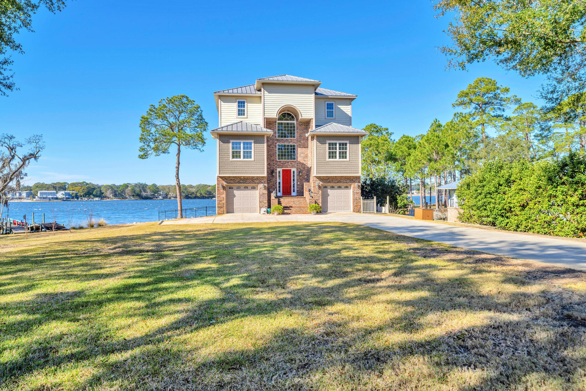 Enjoy peaceful mornings and endless sunsets from absolutely anywhere on this property - not to mention a front row seat to the 4th of July fireworks or just a 20 minute boat ride to Destin! It is evident no detail was overlooked when this custom built home was brought to life.  From the deep water dock with flow-through decking and covered boat lift to the screened porch, elevator, two balconies, chef's kitchen and third floor executive primary suite...you will be so thankful you didn't miss out on the opportunity to make this YOUR home! There are so many amazing upgrades included with this property.  An elevator, full house generator, well-fed sprinkler system, outdoor shower, 2 HVAC's, 2 tankless water heaters, central vacuum, intercom and speaker system, custom kitchen cabinets, hardwood floors and foam insulation to name a few. Entertaining will be a breeze with the first floor kitchen area, gas hook-up for grilling and huge screened porch. An endless deck will help the party flow into the large, fenced backyard. All of your water toys will have a spot on the dock.  Your boat will be protected and easy to use when it is stored on the covered boat lift. Inside this beautiful home water views from every window will be the highlight of the kitchen and living area - or just step out onto the large balcony to relax and enjoy the view. This floor also offers three bedrooms, two full baths and a laundry room. Your primary third-floor suite is an oasis within itself. Every space on this floor is over-sized and over-the-top luxury! You can make your morning coffee at the kitchenette and enjoy it on your private balcony. Back inside - is an amazing bathroom, living space and a separate space for your office where you won't mind working because of it's fabulous views. On the first floor - a great multi-purpose room with half bath, 2 over-sized garages, built-ins and a kitchen are all conducive to living the waterfront lifestyle. Don't forget the ease of access to each floor that is created by having the home elevator at your fingertips as well! This is the home you've been looking forward to owning - don't miss the opportunity to make it happen!