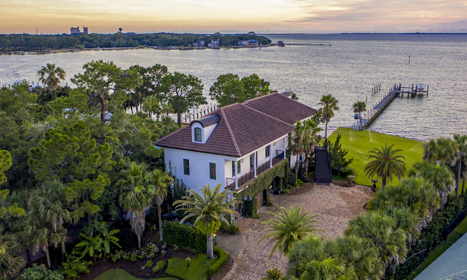 One of the finest lots in Destin, Florida, located in exclusive Cobb's Point! Measuring nearly one acre, with approximately 165' of water frontage at the coveted point of Joe's Bayou and Choctawhatchee Bay, the property features the most desired west-facing orientation, providing stunning sunset views, afternoon light, and a phenomenal deep-water dock that will accommodate large boats! Evoking the classic beauty of old-world France, the home is built with generations in mind. It features many imported finishes, as well as superior ICF construction and modern technologies designed for longevity in the north Florida climate. The flexibility of the 3-story floorplan promotes the interests of generations as well: the main living space and master suite are on the second floor, with 2 additional bedroom suites plus a connecting living area on the third level, and a first floor apartment with another gorgeous master suite, which can either be self-sufficient, or easily reached via connecting stairs or the elevator.  
      
Gorgeous Bois Chamois French white oak floors, shipped from France, comprise the wide-plank floors on the first two floors. In addition to stunning water views, the open entertaining area includes a tea bead chandelier from India setting off the dining area and a coral stone fireplace with surround sound incorporated. Truly one of a kind, the kitchen features Bevolo gas lanterns, old Chicago brick accent wall, a LaCornue range from France with full concrete hood, French Herbeau faucets, custom-painted cabinets, poured concrete countertops, and an amazing island custom built over an antique church altar. Custom woodworking was employed in the adjoining pantry. Nearby are an office, with dual computer desks and hand-carved, antique doors, and a powder room for guests boasting a giant clam shell sink and antique Belgian mirror.
                     
It may look elegant on the outside, but this is a full-fledged dream garage! Over 1300' of conditioned space and bathroom, with 14' ceilings and reinforced concrete designed to accommodate car lifts in each bay, the garage will house 6 cars and the doors are hurricane-rated.   
            
Back out on the water, the pier reaches to 12' of depth, allowing for an 80' boat. The dock has both a 12,000 and 16,000 lb. boat lifts with 50-amp electric service, plus a jetski lift.
        
Throughout the home, storage is unquestionably a priority, including his-and-her walk-in closets in the main floor master suite and a stunning amount of storage in the closets/built-ins and attics of the third floor, all of which is carpeted, heated and cooled. Designed to be energy efficient as well as secure, the home includes 8" of Styrofoam insulation as well as high-impact Kolby windows and doors. The land was elevated to 13' above sea level, which puts it in Zone X (through LOMA) and protects the a/c units and the 16K Siemens whole-home generator.                 
A legacy home in one of Destin, Florida's most spectacular settings!
FEMA LOMA established.