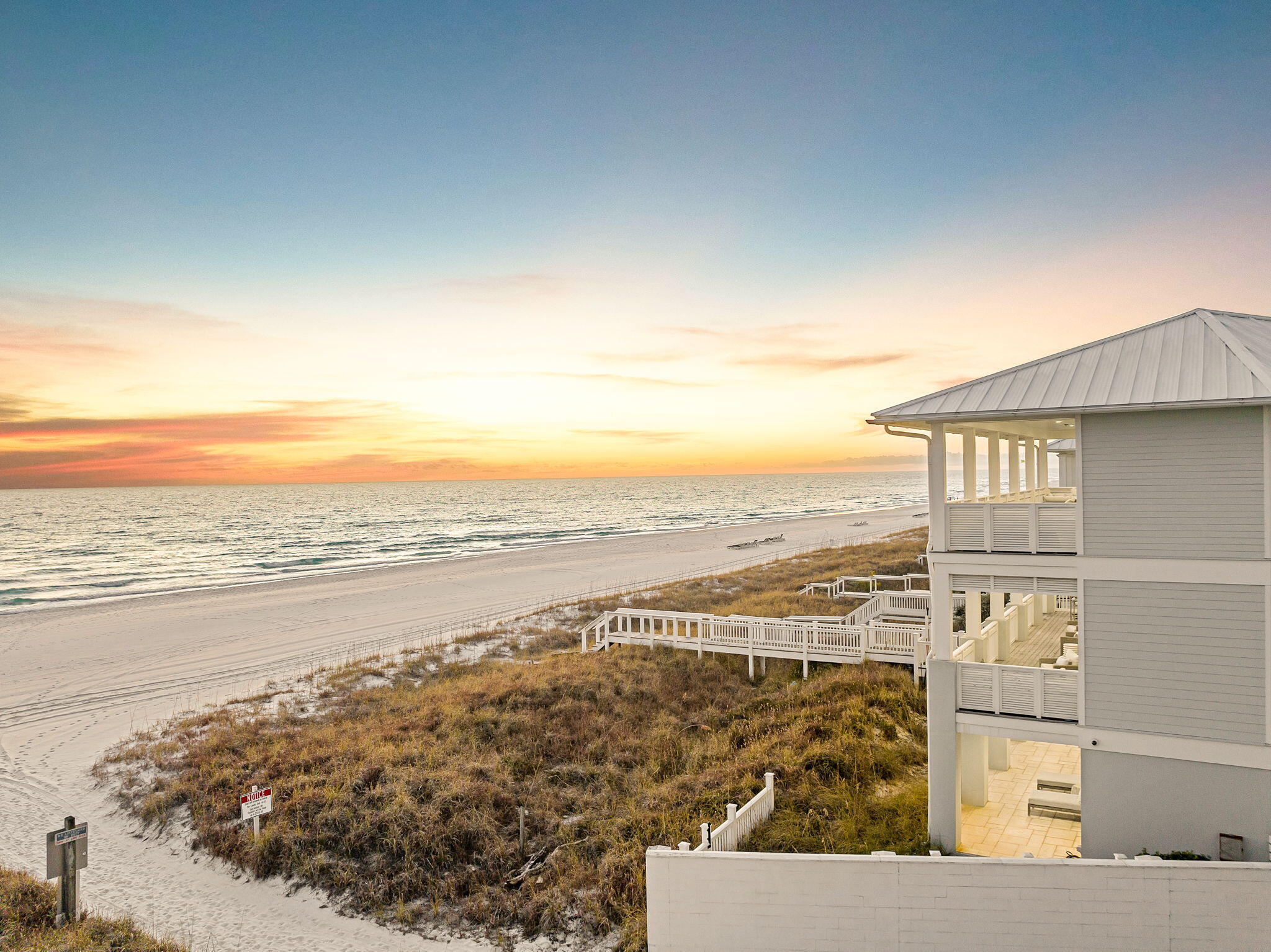 This is not just a beachfront home. It is a 140 foot Gulf front compound inside the gated community of Carillon Beach, one of the most private and tightly held communities on the coast. The lot is exceptionally wide, creating a sense of openness and scale that is nearly impossible to find today. Built in 2019, the modern main residence and separate carriage house together offer more than 6,000 square feet of thoughtfully designed living space, complemented by over 2,000 square feet of covered porches positioned for uninterrupted Gulf views and remarkable sunset evenings. The three-level carriage house enjoys Gulf vistas from every floor, a rare and compelling feature that enhances both privacy and long-term value.

The layout is intentional, balancing expansive gathering areas with private retreats, allowing the property to perform equally well as a personal compound or a high-performing investment. In total, the estate accommodates up to 22 guests across eight bedrooms, seven ensuite bathrooms, and three additional powder rooms.

A private pool anchors the outdoor living experience, while multiple terraces and direct access to an expansive stretch of beach extend the home's livability well beyond its walls. Directly in front of the property lies more than 3,900 linear feet of community beachfront, creating an uncommon sense of space, minimal foot traffic, and a setting that feels quiet and exclusive.

The main house and carriage house may be rented together or independently, offering flexibility for owners seeking income potential without compromising lifestyle. As a legacy family retreat or a luxury rental asset, the property stands apart in scale, width, and irreplaceable beachfront positioning. Opportunities of this caliber are increasingly rare along the Gulf.