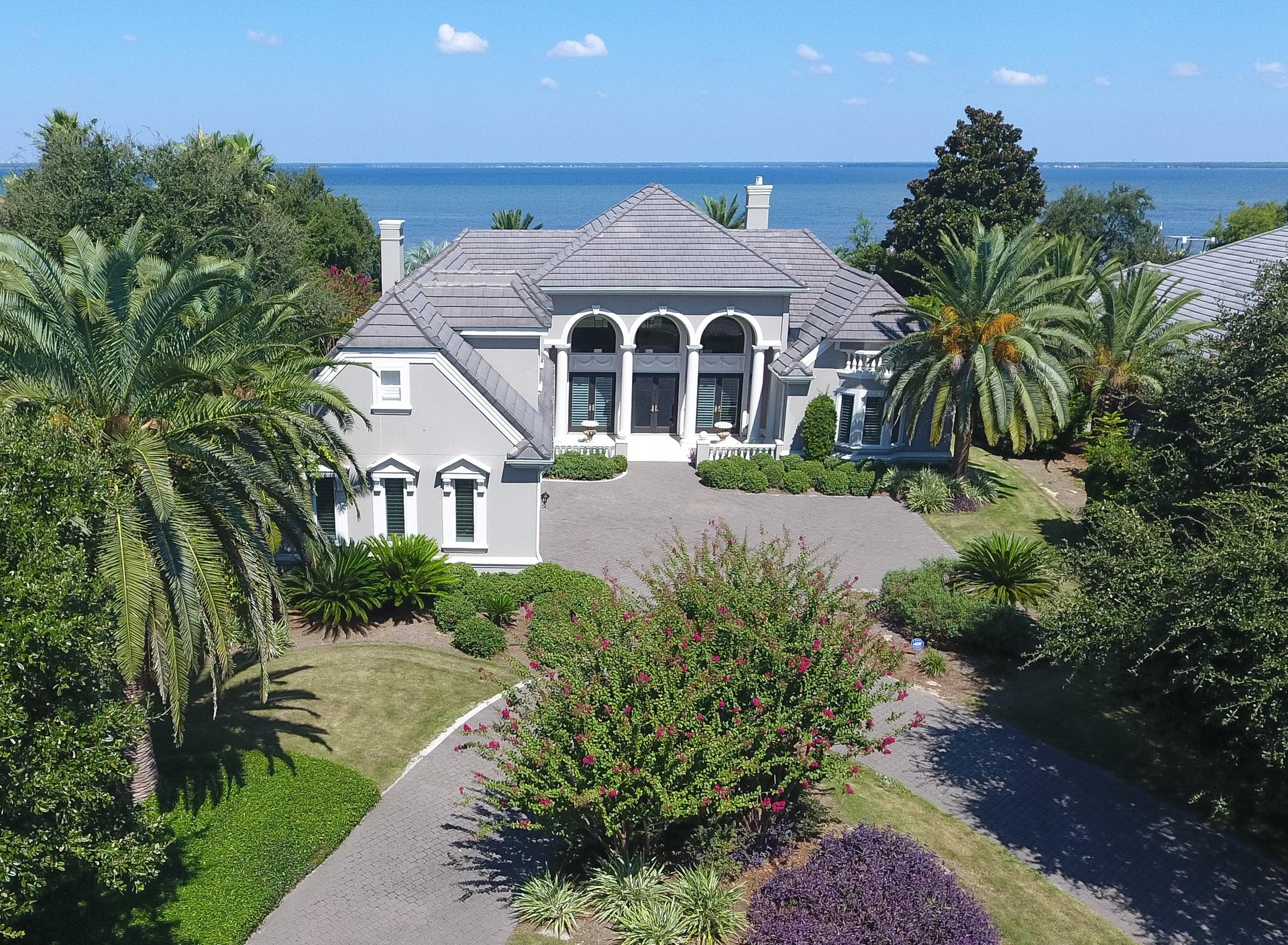 Stunning custom bay front home that is a must see! Great curb appeal with a circular brick paver drive and impressive entrance opening to a grand living and dining area offering the first of many spectacular bay views. Carefully designed floor plan, perfect for family and entertaining, with formal and casual living areas and the master suite all opening onto a large screened lanai with covered outdoor living area, sparkling pool and spa. The gorgeous gourmet kitchen will please the fussiest cook, with Thermadore gas cook top and double ovens, SubZero refrigerator, Bosch dishwasher, tons of custom cabinetry and gleaming granite counters. Roomy breakfast area has mitered glass by window overlooking the pool and bay. There's also a butler's pantry/wet bar located in the hallway, just to the kitchen and formal dining room, as well as a beautifully appointed powder room.  Luxurious master wing with a very spacious waterfront bedroom and sitting area which also open to the lanai and pool, morning kitchen complete with sink and refrigerator, large walk-in closet and a sumptuous master bath with two vanities, walk-in shower, large jetted tub, private water closet. Adjacent to the master suite is a very generously sized office.  Two additional bedrooms and a shared bath comprise the opposite wing.  Large laundry center with deep sink is just off the main hall and has direct access to the three-car garage.  A large bonus room is on the second level over the garage and would make an ideal guest suite (as it is currently used), as it has a large bath with walk-in shower, granite topped vanity, or as an exercise room, playroom, hobby room or climate controlled out of season storage.  Additional custom appointments include surround sound, recessed and art lighting, deep crown molding, under lit cabinetry, custom draperies, recirculating hot water system and much more.  Relax and enjoy the bay views on the screened lanai, complete with large covered patio area, built-in grill, large pool with spa and water feature fountain.  Private boat dock.  Very lightly lived in....this is a must see for the discriminating buyer!