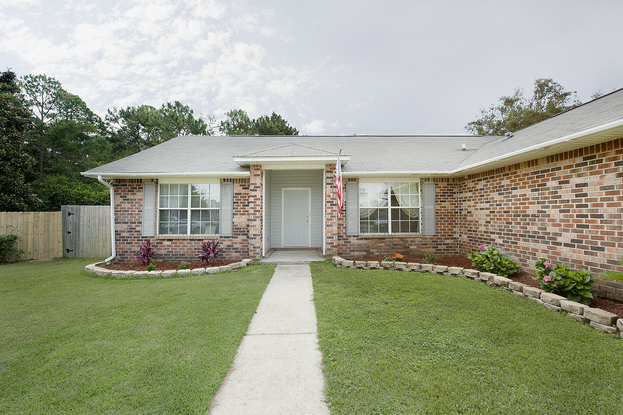 This home has great curb appeal and is located on a quiet cul-de-sac. As you enter you'll notice the large living room, high ceilings, plant ledge, and durable wood floors. The living room connects to a cut out which is perfect for a formal dining area, an office, or play area. The kitchen features tile floors, stainless steel appliances, lots of cabinet and counter space, a large island, a pantry, and breakfast nook. The spacious master bedroom connects to your en suite bath. The master bath boasts tile floors, double vanity, and his-and-her walk-in closets. A beautiful deck looks over your large fenced back yard. Located perfectly between Pensacola and Destin and just minutes from Hurlburt Field and the white sand beaches of Navarre.