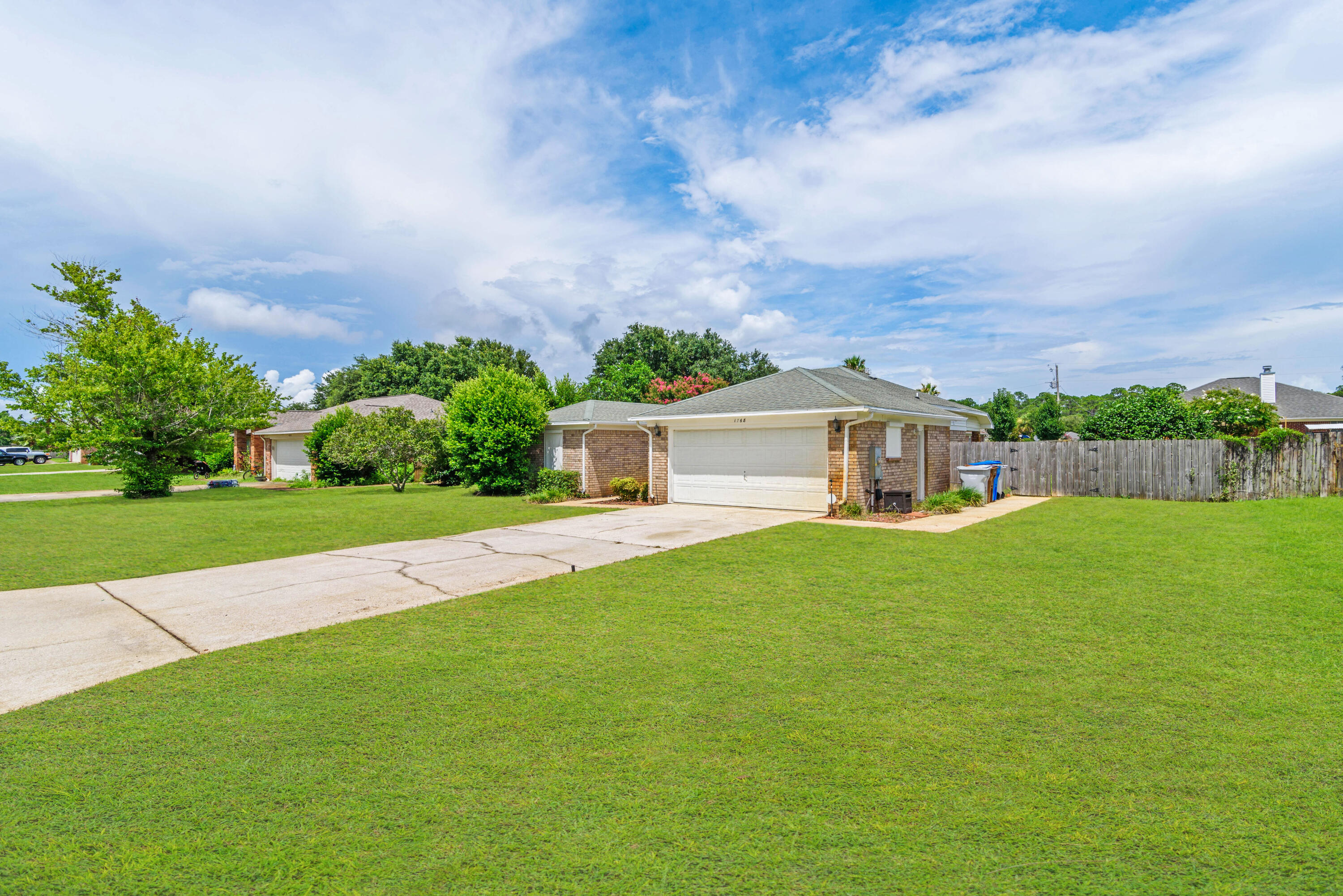 This charming home is nestled in the community of Quayside Village and offers a split floorplan, updated flooring throughout the home and two large outdoor storage/yard buildings. The kitchen comes equipped with solid wood cabinetry with pull-out drawers, electric cooktop, under cabinet lighting and pantry. The primary suite located just off the kitchen, offers beautiful cork flooring and the bathroom has a gorgeous custom tile walk-in shower with a built-in bench, dual shower heads as well as 4 body jets. You'll enjoy dual closets with a linen closet for additional storage and the beautiful herringbone tiled floor. The two additional bedrooms are located on the opposite side of the home and both have gorgeous hardwood floors. The additional bathroom has a shower/tub combo with a hall line This charming home is nestled in the community of Quayside Village and offers a split floorplan, updated flooring throughout the home and two large outdoor storage/yard buildings. The kitchen comes equipped with solid wood cabinetry with pull-out drawers, electric cooktop, under cabinet lighting and pantry. The primary suite located just off the kitchen, offers beautiful cork flooring and the bathroom has a gorgeous tile walk-in shower with a built-in bench, dual shower heads as well as 4 body jets. You'll enjoy dual closets with a linen closet for additional storage and the beautiful herringbone tiled floor. The two additional bedrooms are located on the opposite side of the home and both have gorgeous hardwood floors. The additional bathroom has a shower/tub combo with a hall linen closet. The laundry room has additional solid wood storage cabinets and the washer and dryer convey. Other notables are all brick exterior, gutters, double side gate entry, fully fenced back yard, side door into garage with concrete walkway from garage, front sitting porch, covered patio, sprinkler system, additional freezer in garage and a generator. There is also ceiling fans in all bedrooms and living room which has a solid wood built-in entertainment center and blinds throughout. Located just 9 miles to Navarre Beach and located in Santa Rosa County school distrist. Check out our full video tour on the MLS and YouTube.