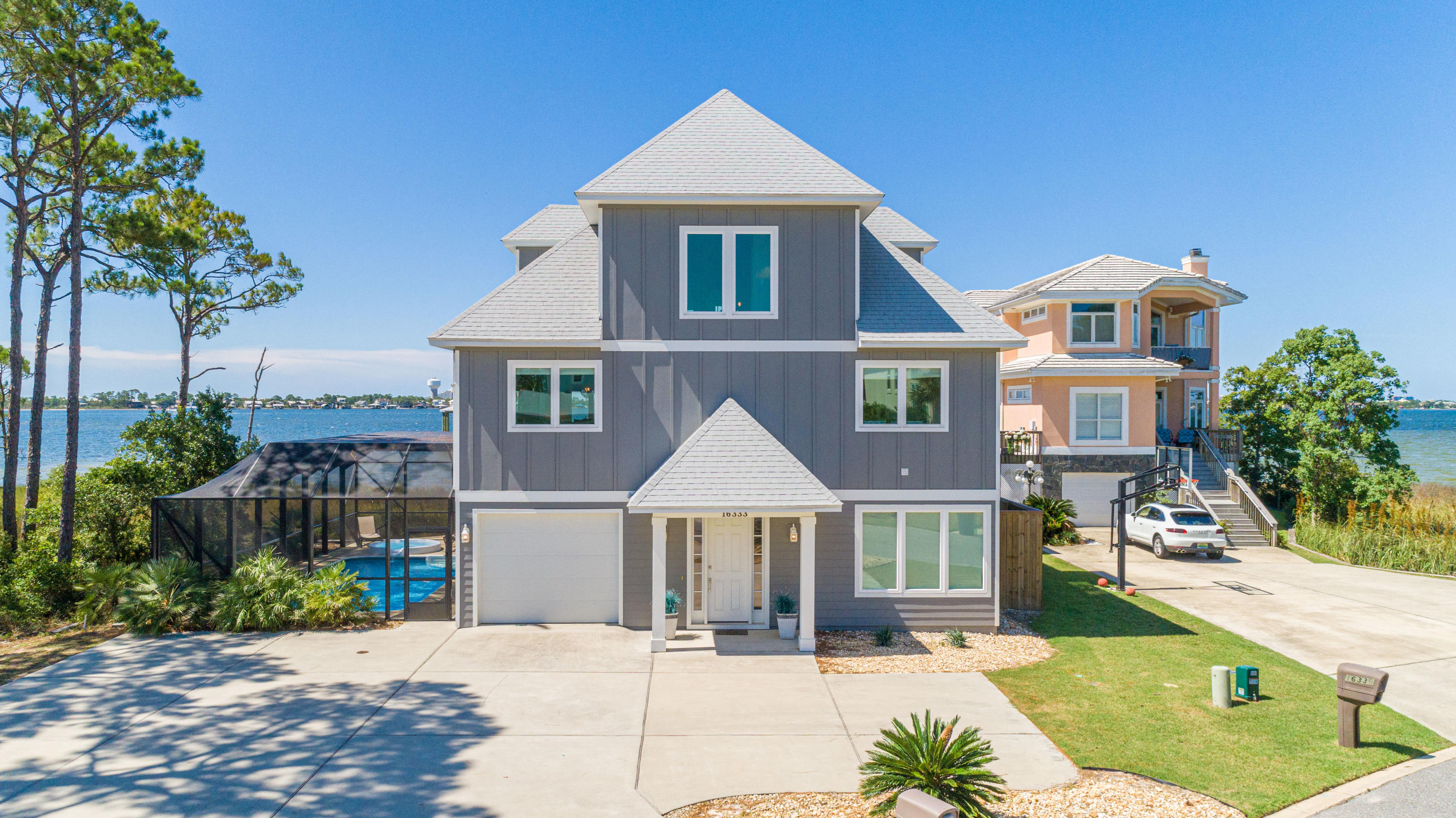 Situated in the gated community of Russell Bayou on Innerarity Island, this custom-built home offers wonderful views of the Bay and Ono Island with 89 feet of water frontage. This home comes equipped with a dock and boathouse, power & water housing 3 spigots, 10,000 pound boat lift (with remote control) with a 30 foot boat slip as well as a convenient fish cleaning station and your very own private beach! Upon entering, you'll note the abundance of natural light, open spacious floor plan with an ELEVATOR to all 3 levels. You'll also enjoy 3 levels of outdoor living/entertaining space which has a 37'x8' covered balcony right off the main living area. The lower level has a screen enclosed porch as well as saltwater pool with a hot tub. The well appointed kitchen has granite countertops, larg e bar area, gas downdraft range, stainless steel appliances, pantry and ample storage space with soft-close Shaker style cabinetry. The waterfront master suite which is on the main living floor, has a walk-in closet and the bathroom a double vanity, oversized soaking tub, separate walk-in shower with beautiful mosaic tile accents and a water closet. The third level hosts 2 additional waterfront master bedrooms with en-suite bathrooms and French doors opening up to a shared balcony. It also features a large loft/living area that sleeps 4 comfortably and a large walk-in storage room.  Other notable features are Econet smart home heating and cooling technology, security system, impact windows, guest parking in driveway, tank less gas water heater, utility sink in laundry room, small boat lift for small boat or kayak. Being sold furnished. Pool measures 28x14. Enjoy the community tennis court as well as the security of a double gated community. Check out our full video tour on the MLS and YouTube.