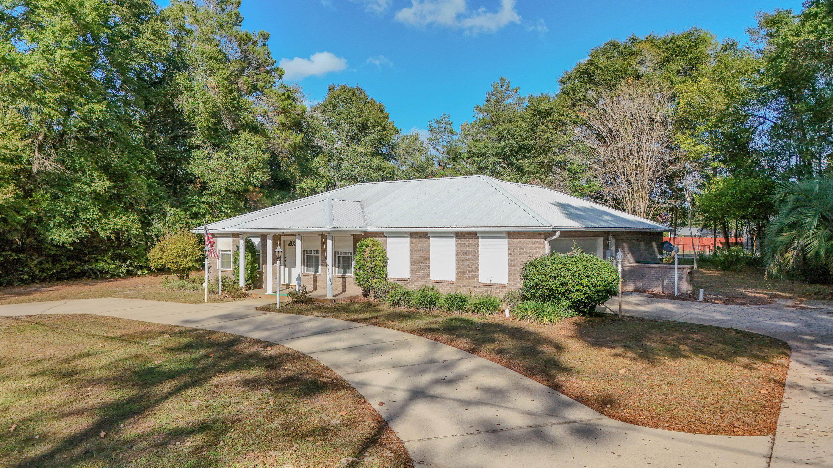 This one offers far more than what looks simple driving by. The sellers built it like they were preparing for the next century of Florida weather. If you want a low-maintenance snowbird spot or a retiree-friendly fortress you can lock and leave without a second thought, this one checks the boxes. The solid brick home features 2 bedrooms, 2.5 baths, and a 2 car attached garage finished in easy-care tile and vinyl (yes, even the oversized garage is tiled). The kitchen is oversized, the interior is spotless, and yes, it's ready for your personal touch, which is Realtor-code for ''the bones are great, bring your imagination.'' Out back you'll find an 18x45 RV cover with full hookup, plus an attached storage building that's already plumbed for a sink and commode. The added separate worksho with with a roll-up door and built-in shelving doesn't disappoint. So if you have tools, hobbies, a need to tinker or simply need extra on-site and easy to access storage, you're covered. Convert one of these buildings into a tiny home if you want extra living space or a long-term guest or rental setup. Safety features here are next-level:
Steel-cabled tie-downs on porches and buildings, steel rods on every window, hurricane shutters, and an authentic safe room that's even equipped with an escape hatch. You'll find 2 HVAC units, including a dedicated system just for the master suite. The property has city drinking water and a well for irrigation, which is a small but mighty win when the water bill rolls around. Conveniently accessed from 2 streets - both front and rear. Located less than 5 minutes to downtown DeFuniak Springs and 30 minutes to the sugar white sands. The seller is also open to owner financing with acceptable terms and a vetted buyer, which makes this opportunity even sweeter. If you want something strong, simple, and set up for an easy life in the FL panhandle, come see this one in person. It might surprise you.