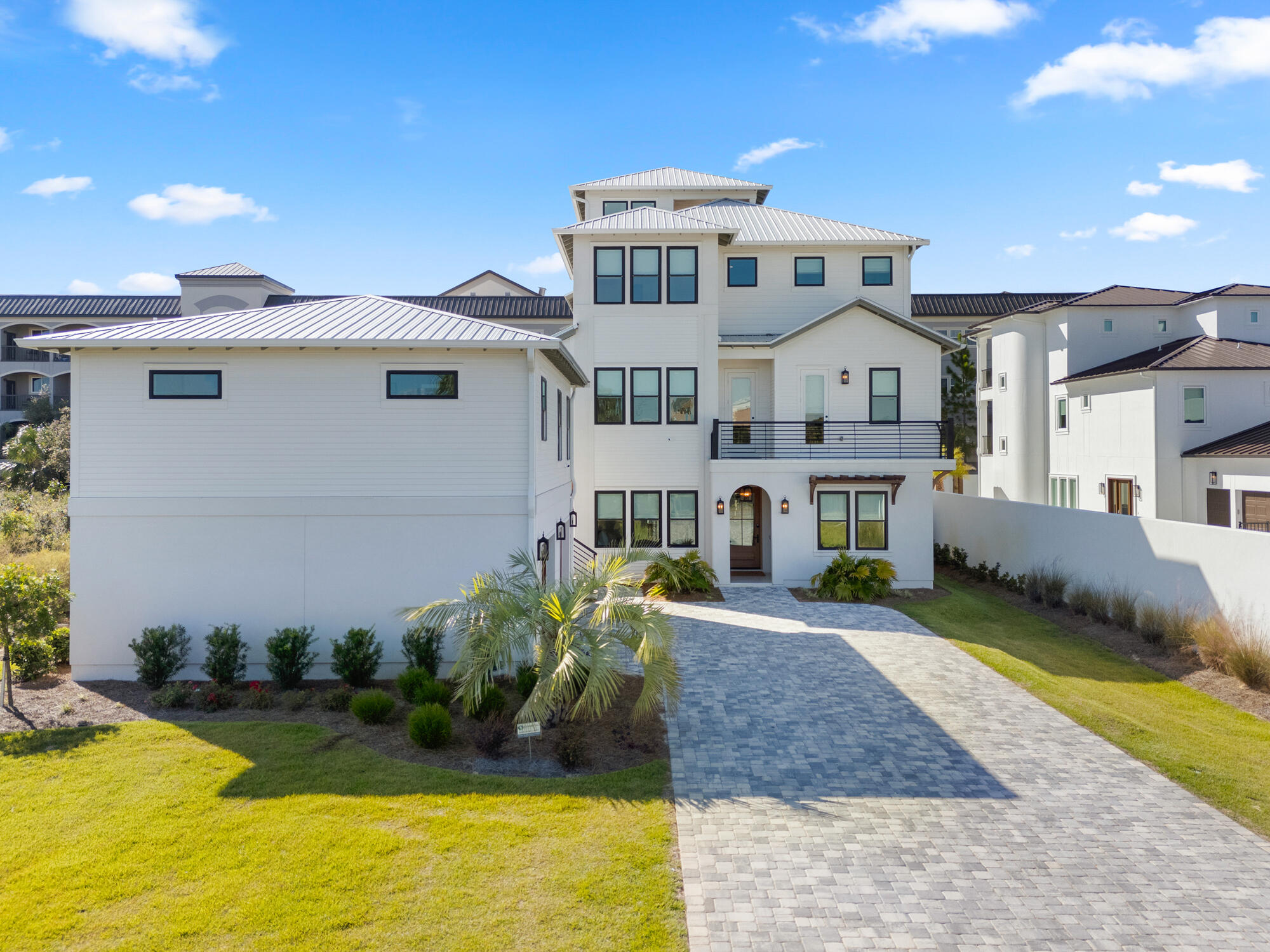 Discover unparalleled luxury in this expansive 2023 built nine-bedroom residence located in Miramar Beach, just minutes from the pristine sands of the Gulf of Mexico. The home features seven king suites and two bunk rooms, complemented by nine full bathrooms and four half baths, ensuring ultimate comfort and privacy for all guests. Thoughtfully designed with custom-curated art and décor, the interior exudes coastal elegance with shiplap walls in various areas and wood-trimmed ceilings enhancing the 2nd floor open-concept kitchen, living, and dining areas. Upon entry, the main level offers private king suites with en-suite bathrooms, a bunk room with six built-in twin beds and its own bathroom, plus a guest half bath. An elevator provides easy access to all levels. The poolside game room invites friendly competition with a ping pong table, shuffleboard, two smart TVs, and a custom lounge area, opening directly to an entertainment-focused backyard oasis.

The expansive outdoor area features a covered summer kitchen equipped with a grill, ice maker, sink, wall-mounted outdoor TV, and Sonos sound system, plus a convenient half bath. The centerpiece is a heated pool with a waterfall wall, built-in concrete stools, and a luxurious spa. Surrounding amenities include hammocks swaying in the breeze, a three-hole putting green, fire pit area, lush tropical landscaping, ambient lighting, and a pergola with outdoor seating and café lights enhancing the resort-like ambiance.

Ascend via elevator or shiplap-accented staircase to the second floor, where a chef's dream kitchen awaits. It's equipped with luxury Café series appliances including a refrigerator, gas range, two dishwashers, beverage cooler, ice maker, and a large island with additional seating. The adjacent dining area comfortably seats all guests, accented by unique vintage-style local artwork. The adjoining living area includes a large wall-mounted TV, chairs, and sofa for peak relaxation. This level also hosts king suites with tiled walk-in showers; one suite additionally features a separate clawfoot bathtub, offering serene retreats for guests. A small front balcony accessible from one of the bedrooms and a hallway provides multiple vantage points to enjoy the surroundings, while a large covered rear balcony overlooking the pool area offers both shaded and unshaded spaces ideal for morning coffees or evening cocktails.

On the third floor, an entertainment haven awaits with an additional living area featuring a wall-mounted TV, comfortable sofa, and three arcade cabinets, creating the perfect spot for family fun and leisure. A convenient coffee bar equipped with its own ice maker and drink cooler adds to the allure. Between the king suites with luxurious walk-in tiled showers, there's an additional sitting area with a built-in countertop. For larger groups or families, an additional bunk room accessed through a barn door features four custom-built bunks and an en-suite bathroom thoughtfully integrated to accommodate everyone's needs. A large covered balcony with outdoor seating overlooks the pool area, accessible directly from the bunk room and the living area.

At the pinnacle of this exquisite home, the rooftop bar and lounge offer a space designed to elevate your experience both literally and figuratively. This rooftop oasis blends relaxation and entertainment, featuring a unique bar area with charming swing seating and a wall-mounted TV. Enjoy views of the Gulf of Mexico from both covered and open seating areas. Under the shaded section, unwind with a refreshing drink, while the open seating area centers around a fire pit perfect for evening conversations.

An adjacent carriage house offers a private and luxurious retreat, perfect for couples seeking extra privacy or guests desiring a secluded getaway. It features a spacious bedroom suite, a spa-like bathroom with a jetted soaking tub and a tiled walk-in shower featuring a rainmaker showerhead and additional water controls, complemented by a mirrored changing room. The kitchen boasts stainless steel appliances including a refrigerator, ice maker, and dishwasher alongside custom cabinets and open shelving. A comfortable living area furnished with a sofa and a wall-mounted TV provides an inviting atmosphere for unwinding after a day at the beach or exploring local attractions. Beneath the carriage house are two single garage stalls one equipped with an EV charger and an additional washer and dryer provide convenience and cater to larger groups, ensuring a seamless experience for all guests.

Following a successful inaugural year on the rental market and with bookings already secured into 2025, this property is not just a luxurious residence but also a promising investment. Meticulous attention to detail, captivating architectural elements, and a stunning array of carefully curated artwork create a vibrant atmosphere, blending sophisticated design with luxury amenities and a promising start in the rental market. 

Immerse yourself in a lifestyle that seamlessly blends luxurious interior comforts with exquisite outdoor amenities. Tailored for those who appreciate the finest in coastal living, this exceptional residence is conveniently located south of US Hwy 98 in Miramar Beach just minutes from the beach, shopping, restaurants, entertainment, and the pedestrian path that runs the entire length of Scenic Gulf Drive. Don't miss the chance to experience this unparalleled luxury retreat.
